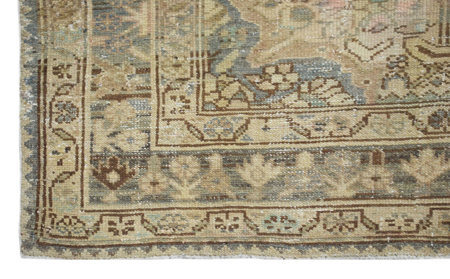 A vintage handwoven Persian runner featuring a faded floral pattern in muted earth tones.