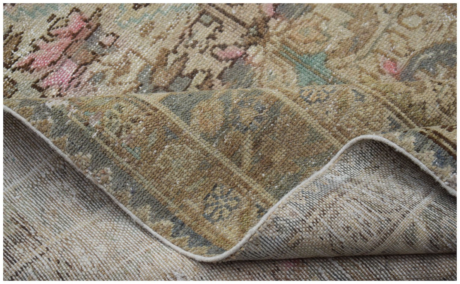 A vintage handwoven Persian runner with a faded, distressed pattern in muted earth tones.