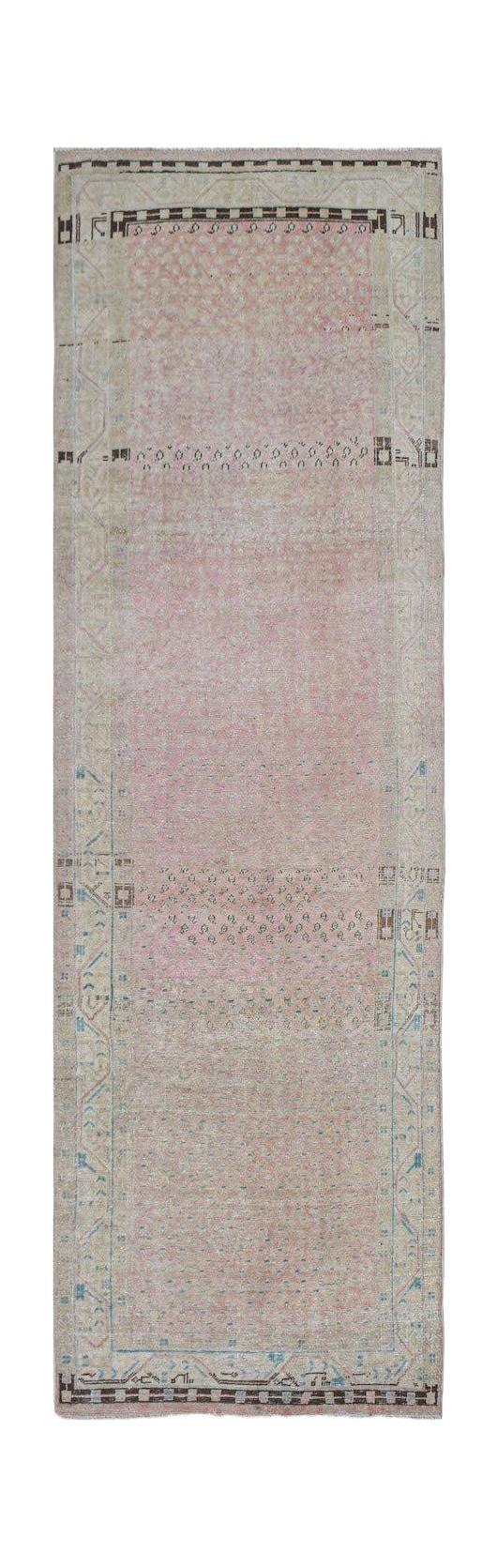 Vintage Persian runner rug with a pink field and geometric borders.