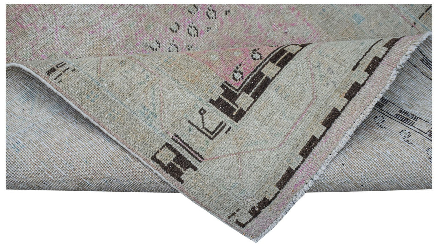 Vintage Persian runner rug with geometric patterns in brown and pink.