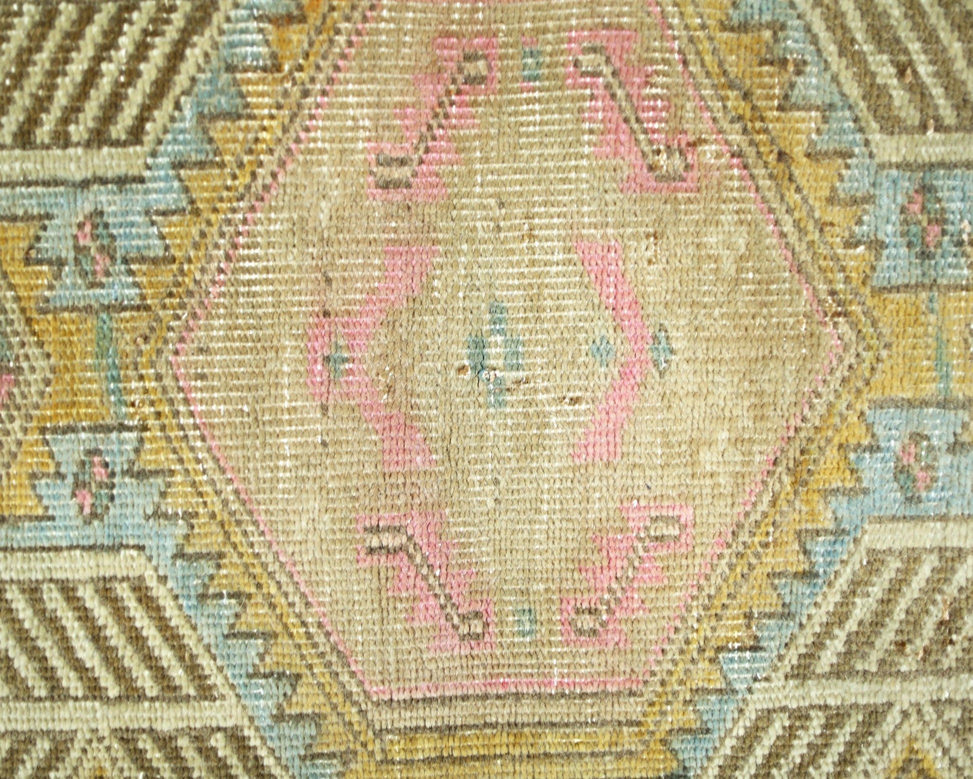 A vintage Persian runner featuring a geometric hexagonal pattern in muted pink, blue, and gold.