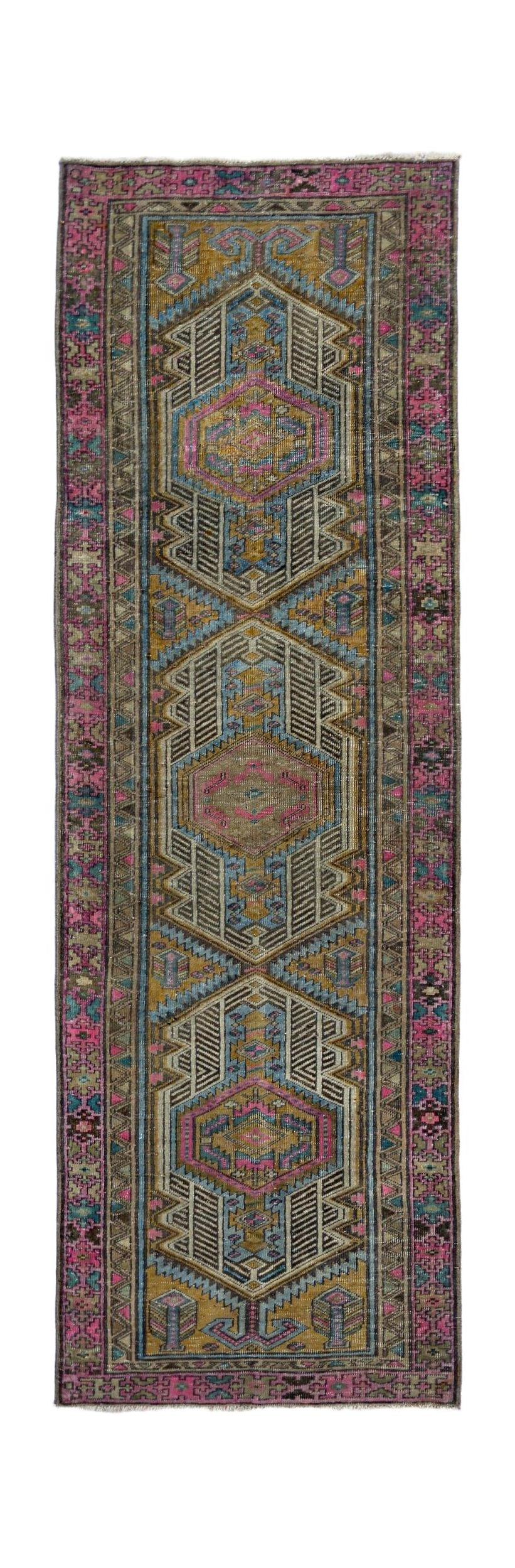 A vintage Persian runner featuring geometric medallions in vibrant pink, blue, and gold tones.