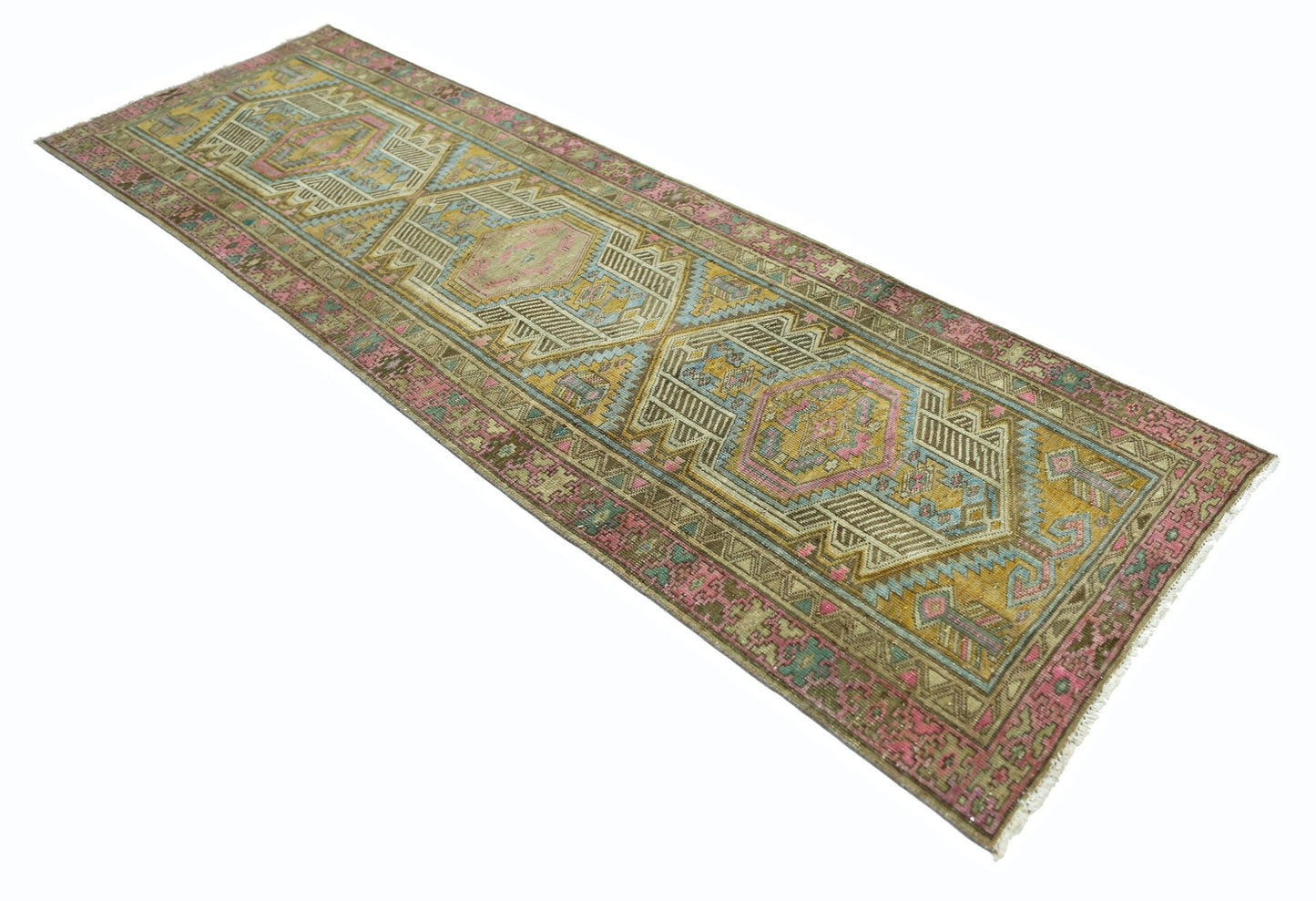 A vintage Persian runner rug featuring geometric patterns in shades of pink, blue, and gold.