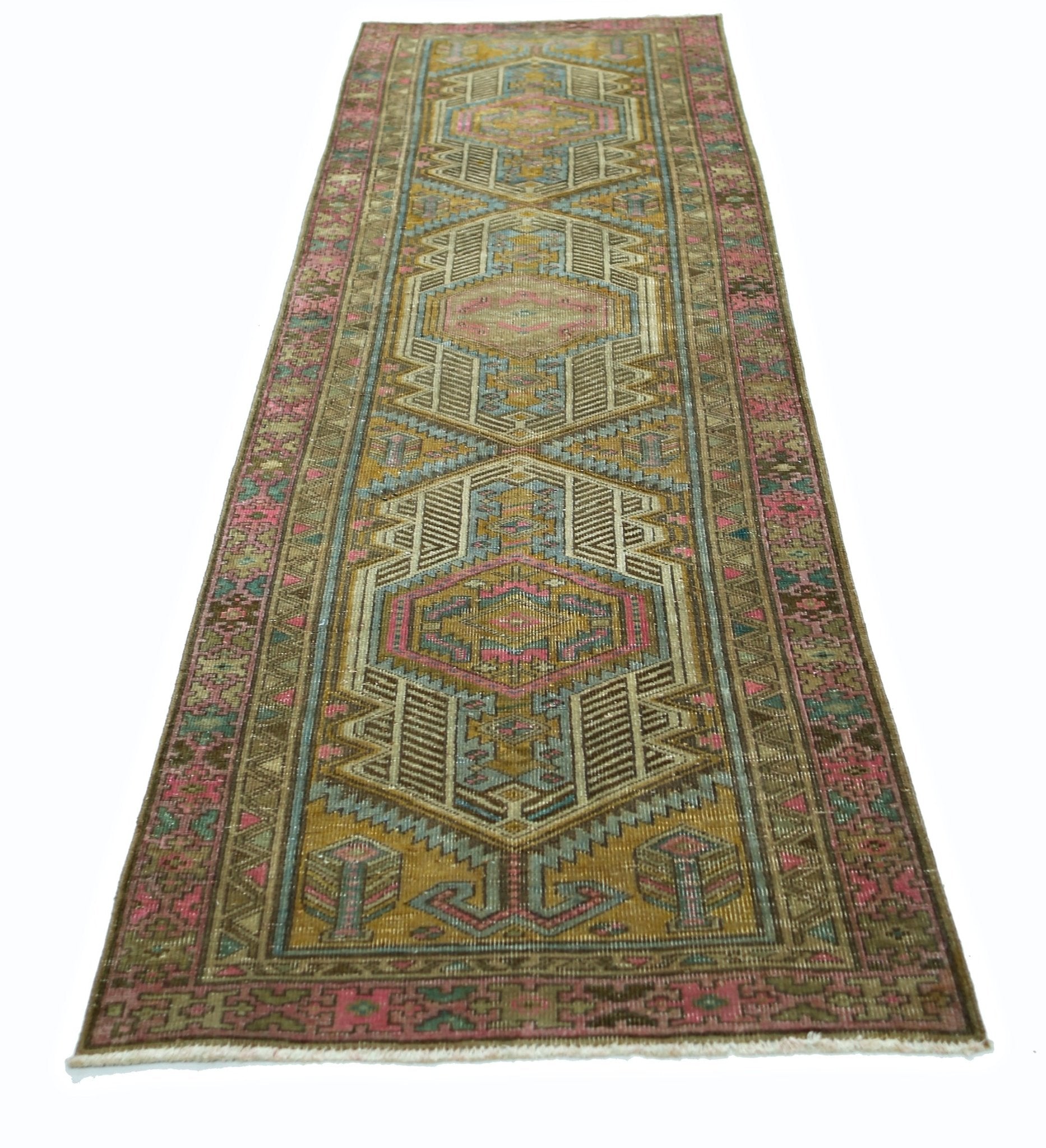 A vintage Persian runner rug featuring geometric patterns in shades of pink, blue, and gold.