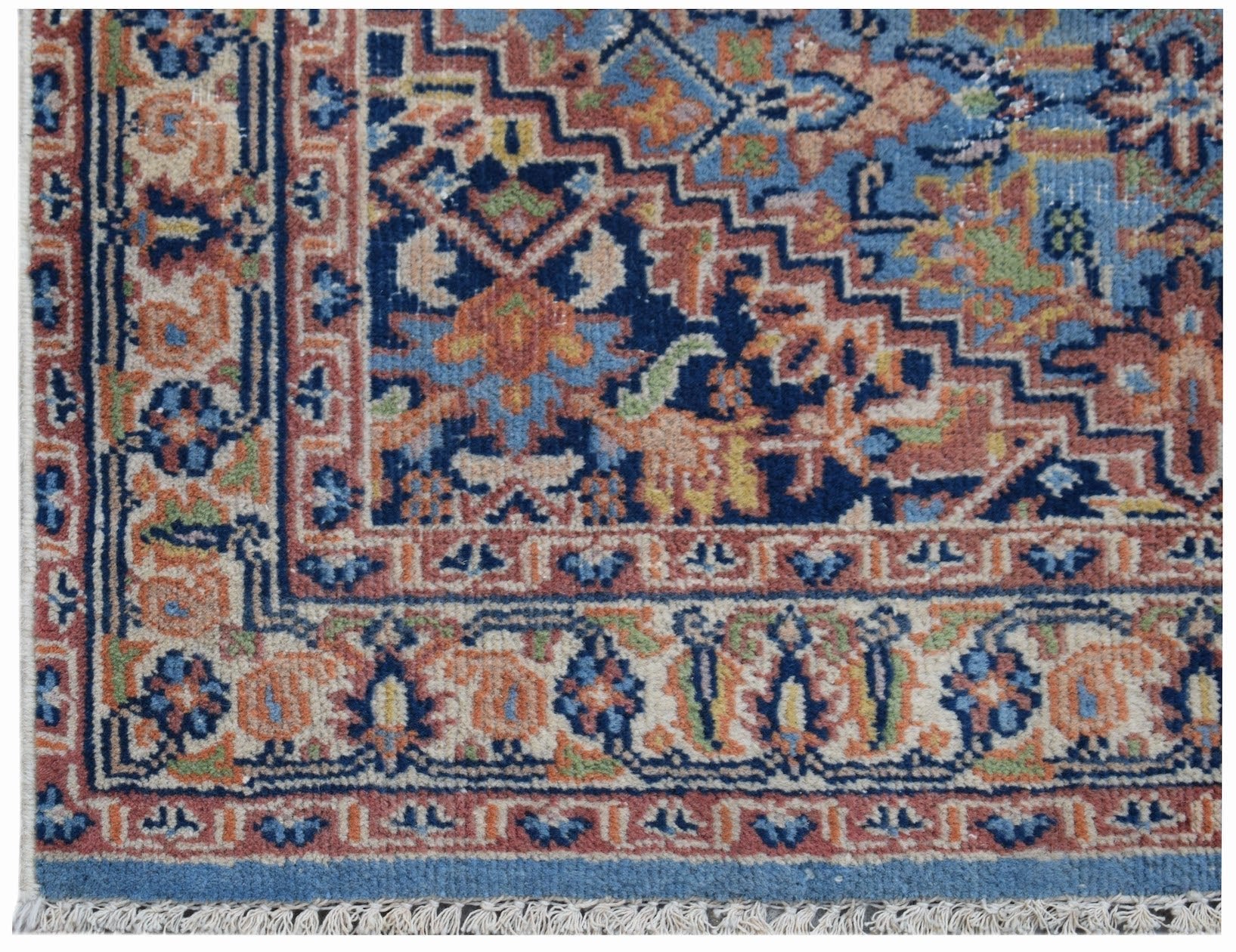 A vintage Persian runner featuring a geometric floral pattern in blue, orange, and cream tones.