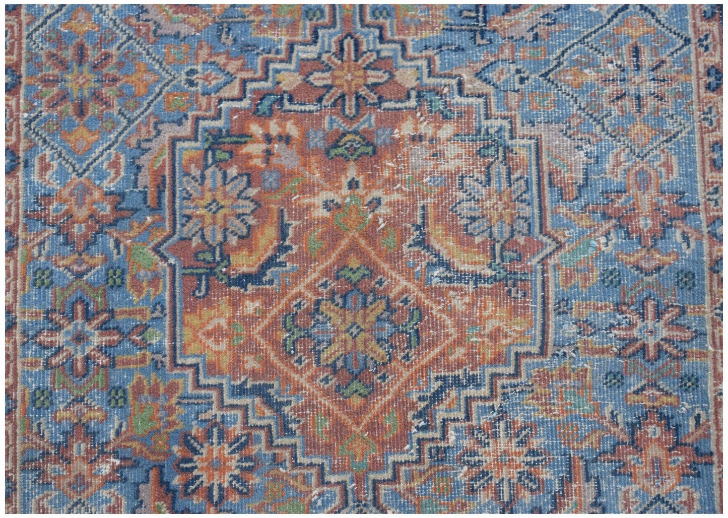 A vintage Persian runner featuring a geometric floral pattern in shades of blue, orange, and green.