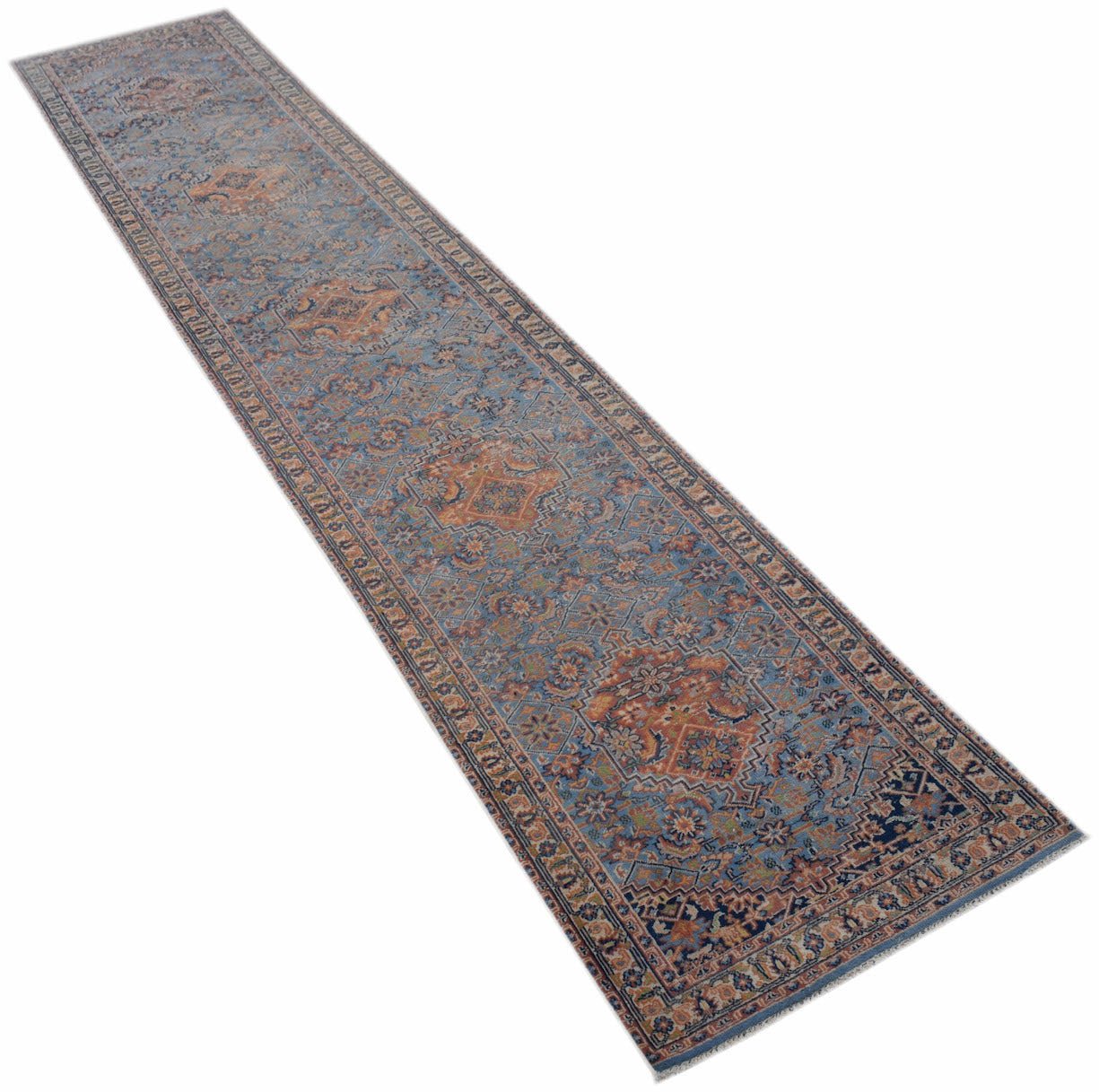 A handwoven vintage Persian runner rug featuring a faded blue and orange floral pattern.