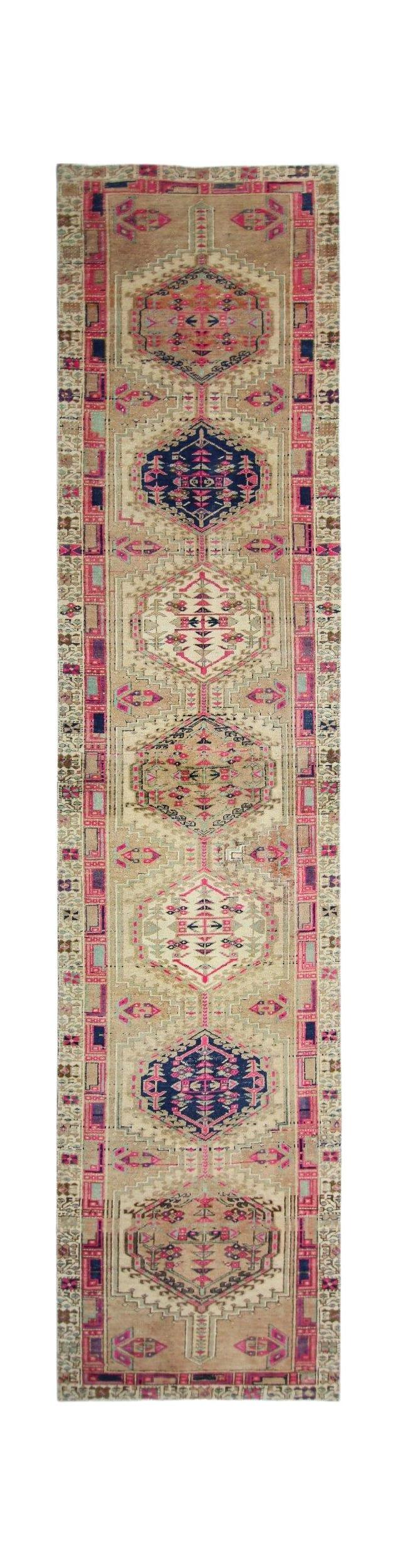 A vintage Persian Hamadan runner featuring geometric medallions in pink, blue, and beige tones.