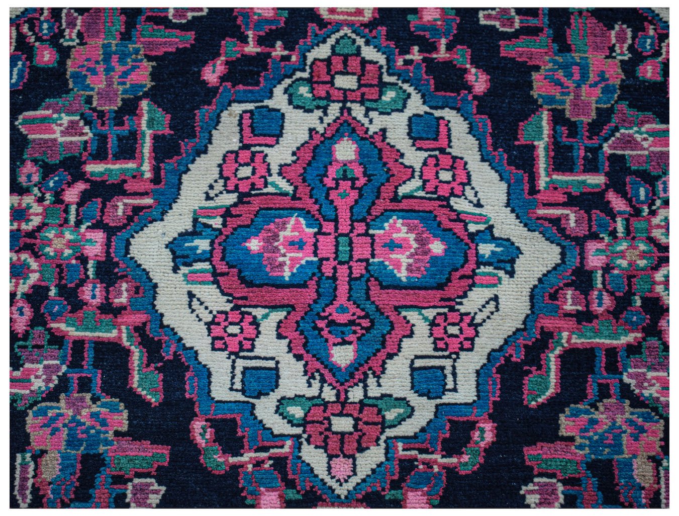A vintage Persian Hamadan runner featuring a central floral medallion in pink, blue, and cream.
