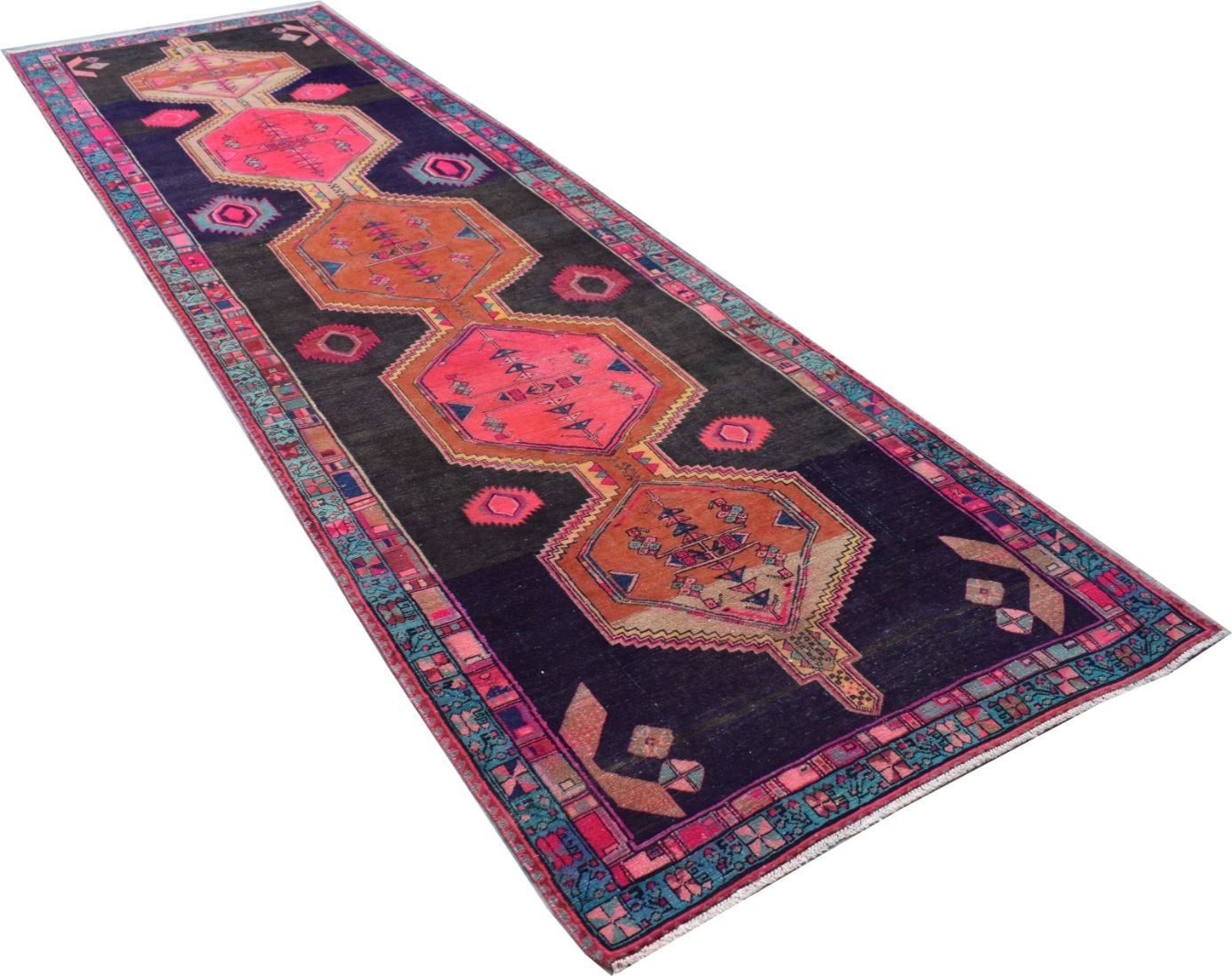 A vintage Persian Hamadan runner featuring geometric medallions in pink and orange on a dark field.