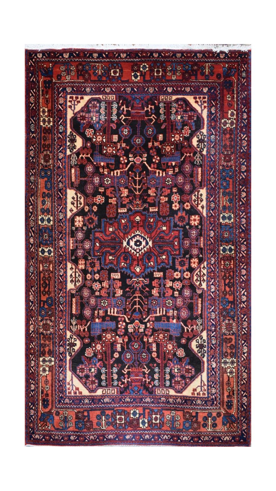 A vintage handwoven Persian Hamadan rug featuring a dark central medallion on a red and blue field.