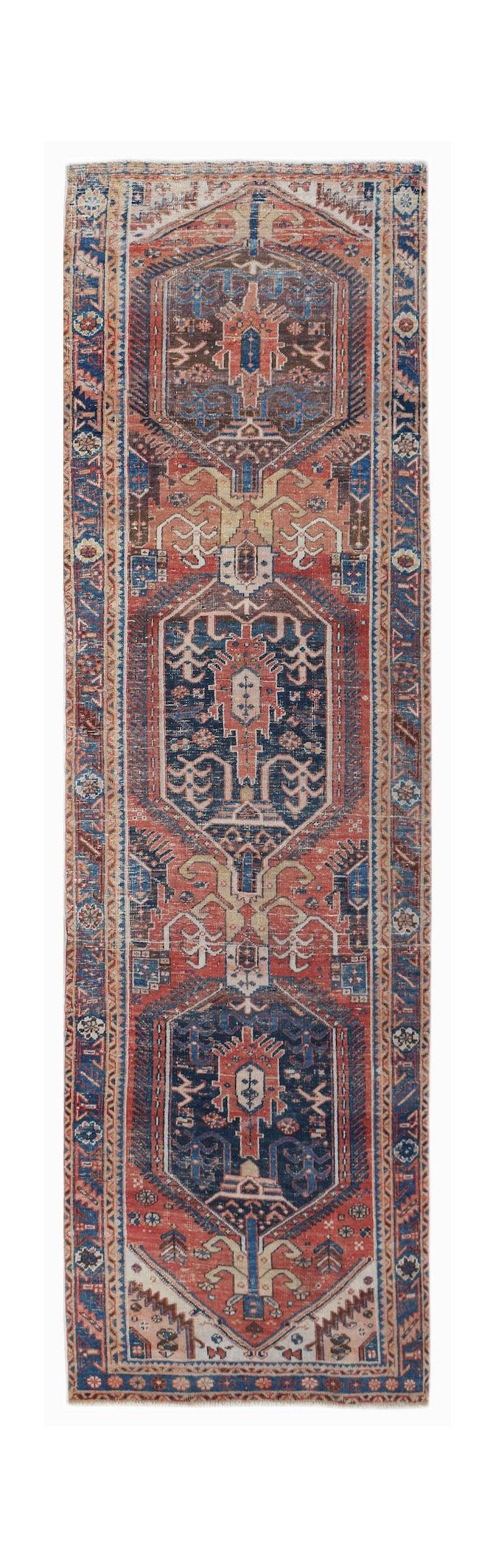 A vintage handwoven Persian Hamadan runner rug featuring geometric medallions in red and blue.
