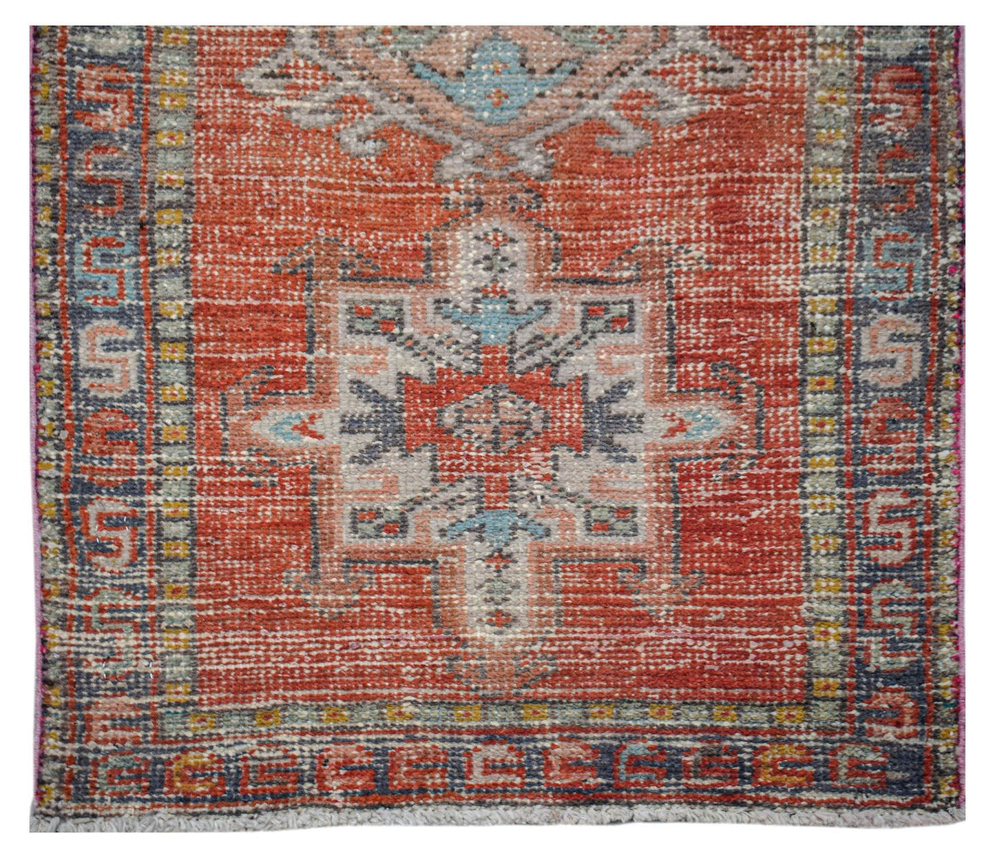 A vintage handwoven Persian Karaja runner featuring a geometric medallion on a red wool field.