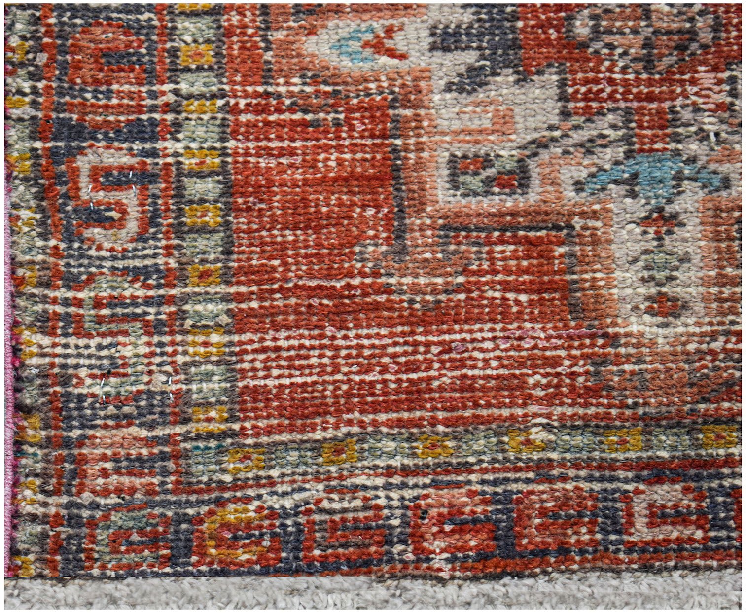 A vintage Persian Karaja runner featuring a geometric pattern in red, blue, and yellow wool.