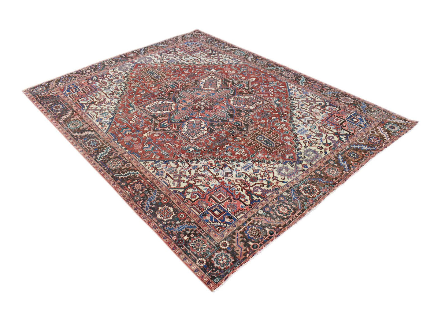 A vintage handwoven Persian Heriz rug featuring a geometric medallion on a red field.