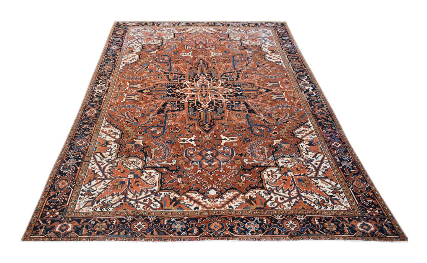 A vintage handwoven Persian Heriz rug featuring a geometric medallion on a rust-colored field.