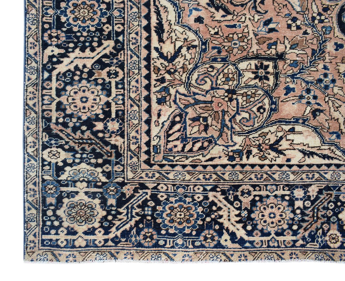 A vintage Persian Heriz rug featuring a geometric floral pattern in shades of blue and peach.