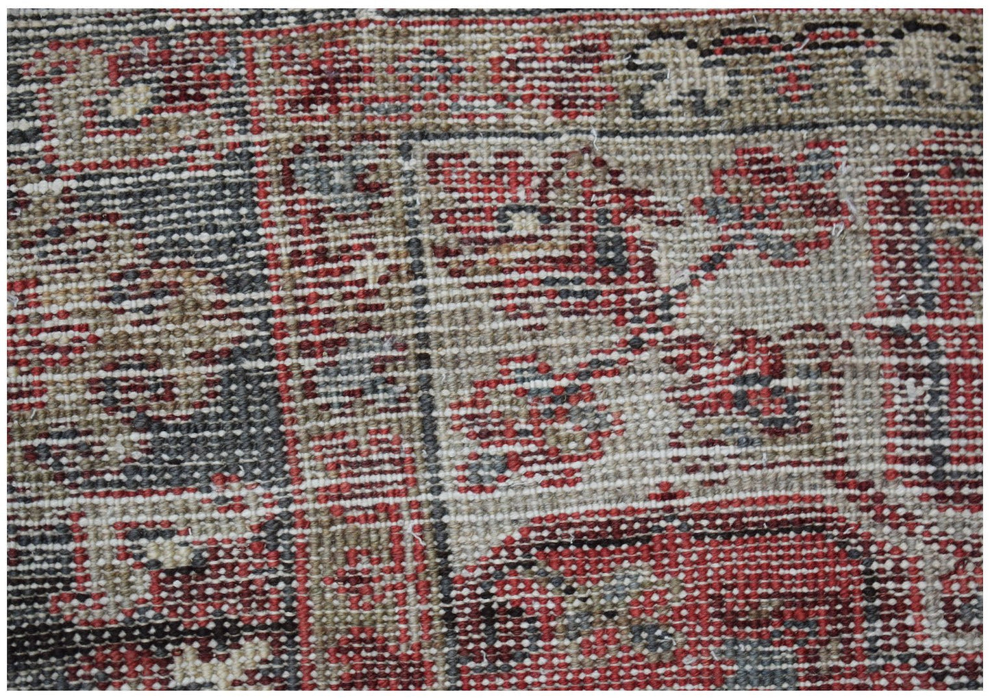 A close-up view of a vintage Persian Heriz rug featuring intricate geometric patterns in wool.