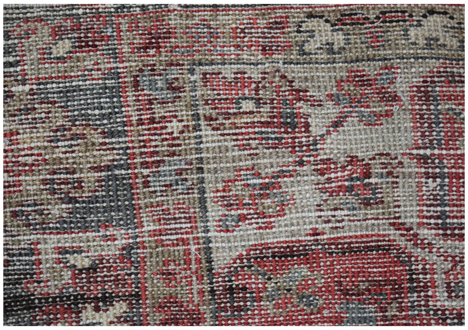A close-up view of a vintage Persian Heriz rug featuring intricate geometric patterns in wool.