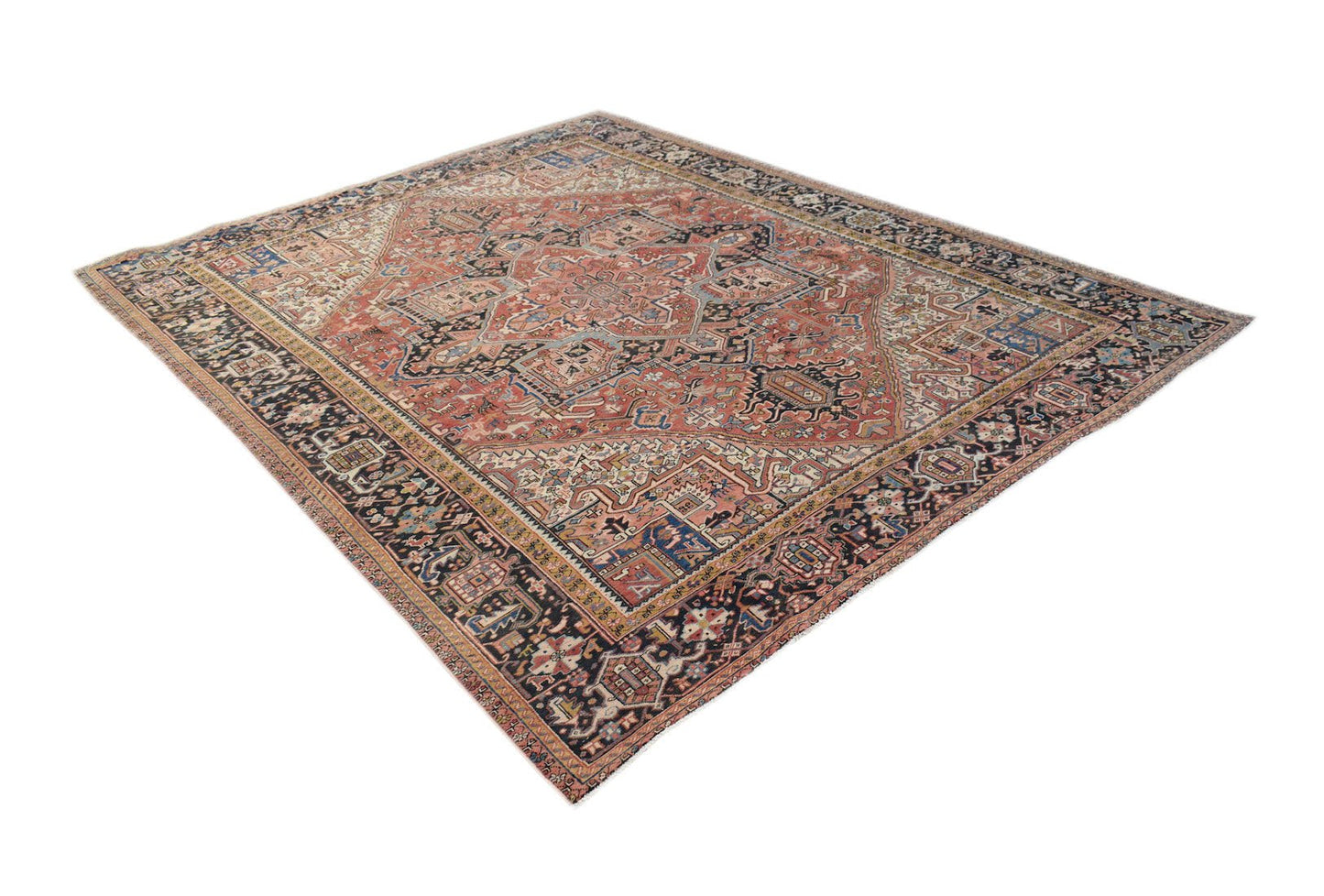A vintage handwoven Persian Heriz rug featuring a geometric medallion on a terracotta field.