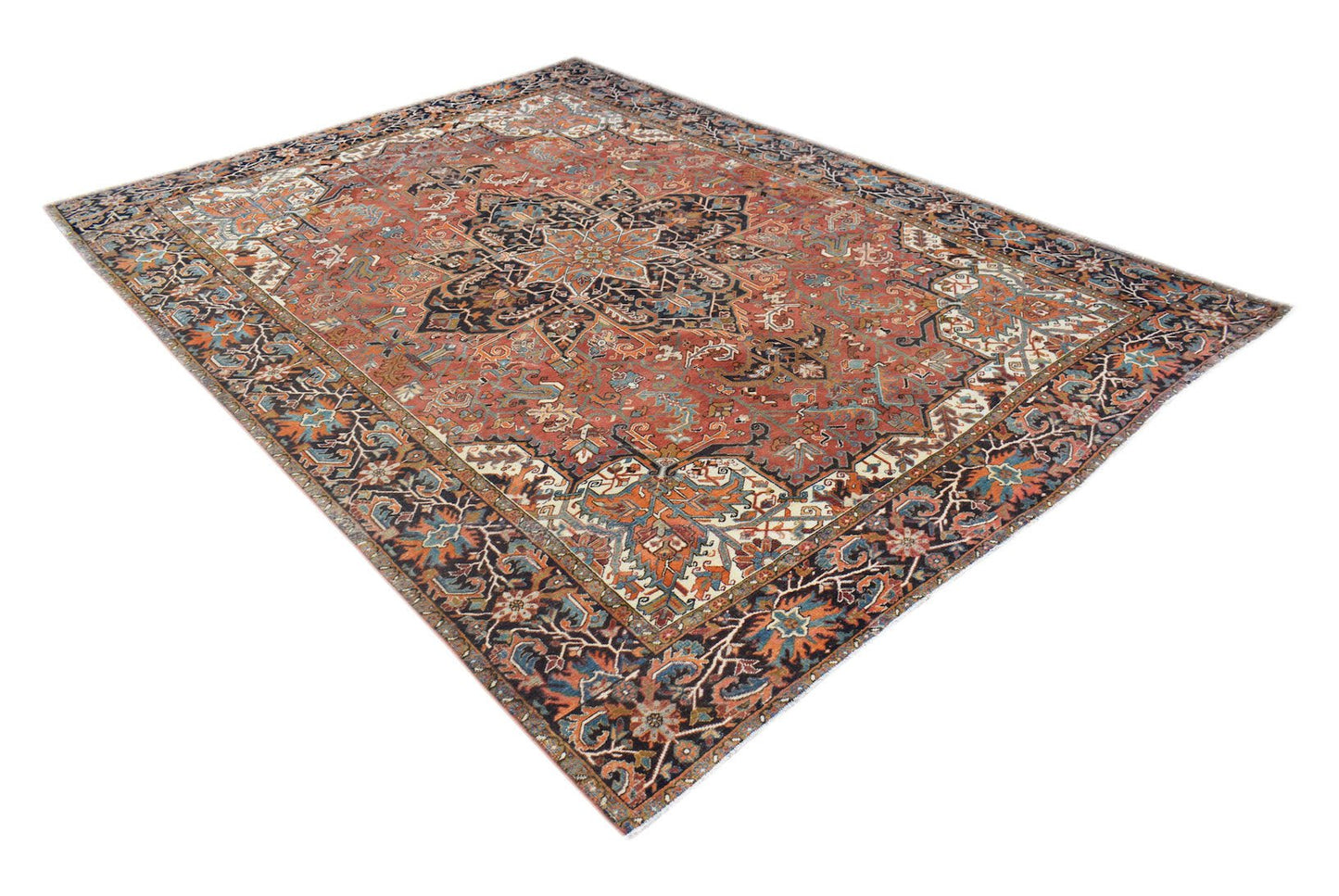 A vintage handwoven Persian Heriz rug featuring a geometric medallion on a rust-colored field.