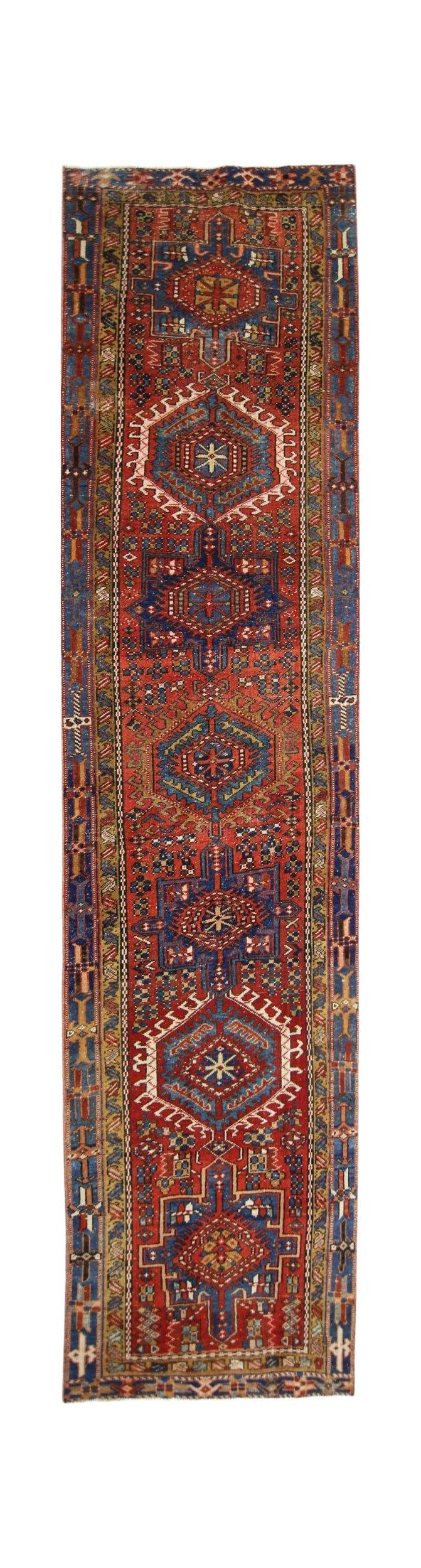 A vintage Persian Karaja runner featuring geometric medallions in red and blue wool.