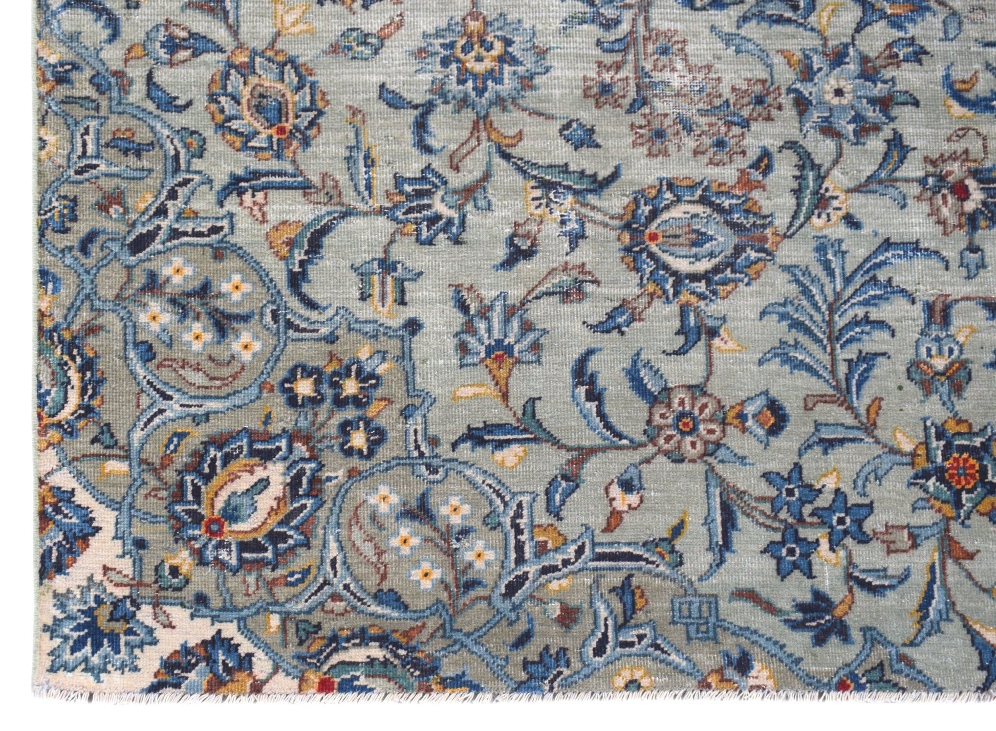 A vintage Persian Kashan rug featuring intricate floral patterns in blue and cream tones.