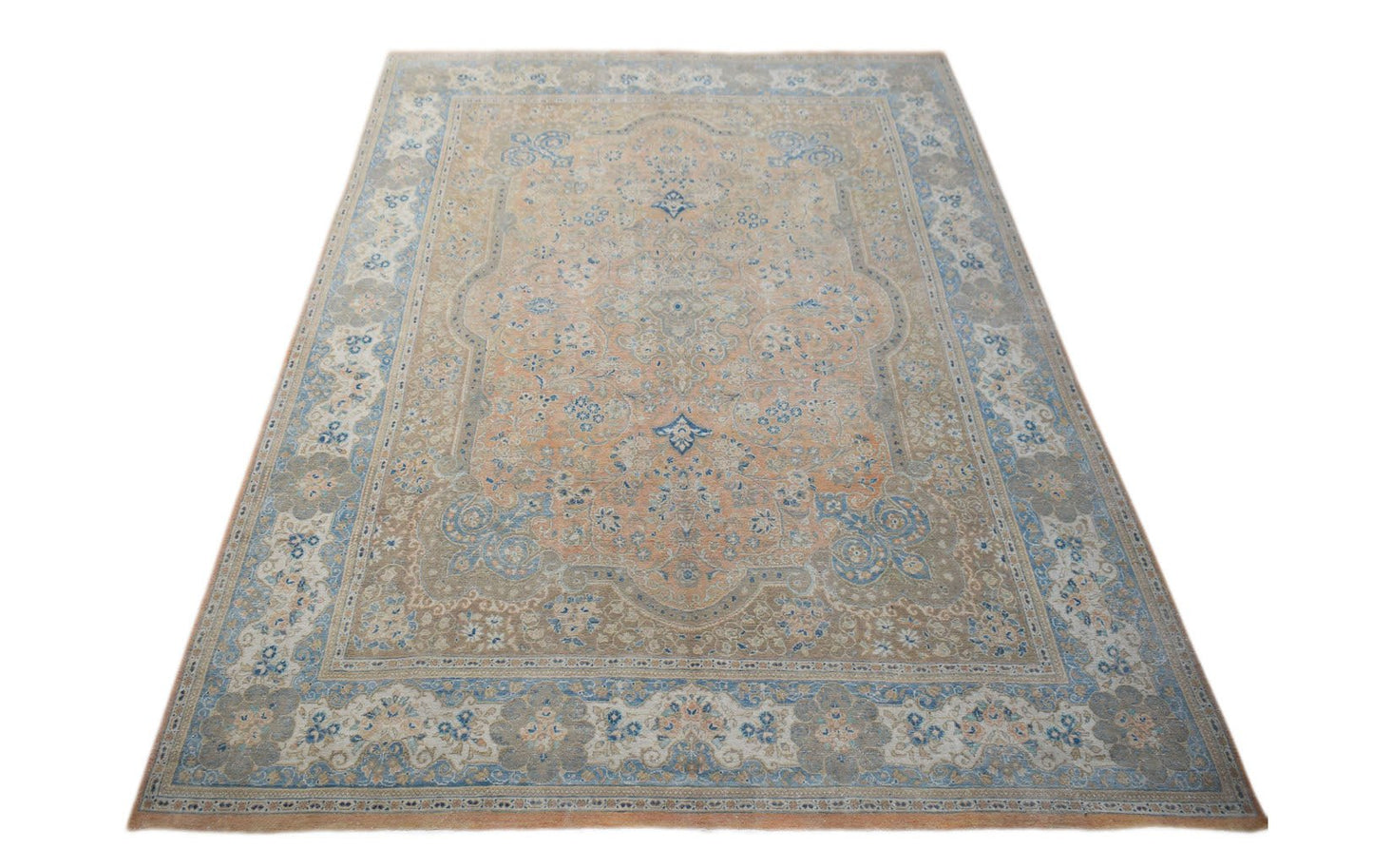 A vintage Persian Kashan rug featuring a central floral medallion in soft peach and blue tones.