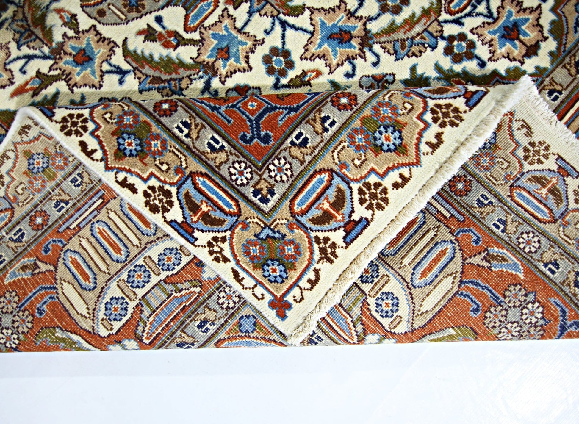 A vintage Persian Kashmar rug with intricate floral patterns in blue, red, and cream tones.