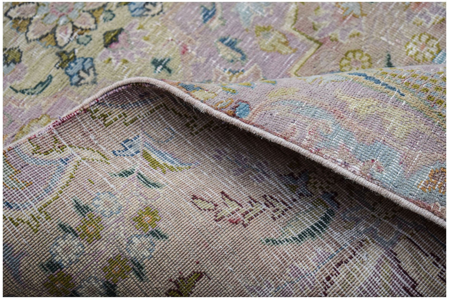 A close-up view of a vintage Persian Kerman runner showing its intricate floral pattern and weave.