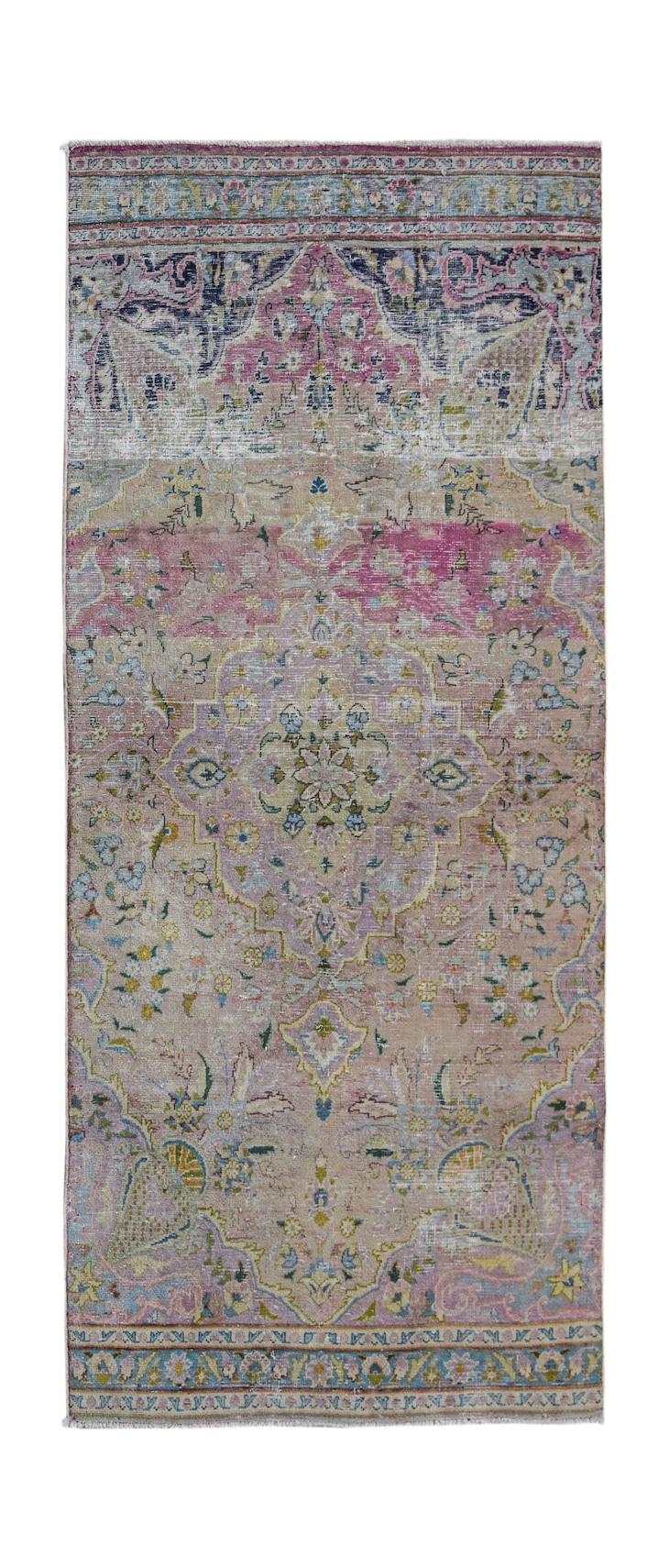 A vintage Persian Kerman runner featuring a central floral medallion in muted pink and blue tones.