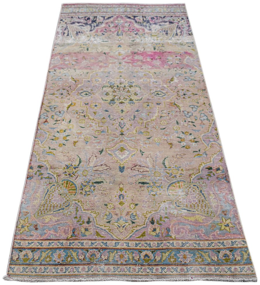 A vintage Persian Kerman runner featuring a central medallion and intricate floral motifs in pink.