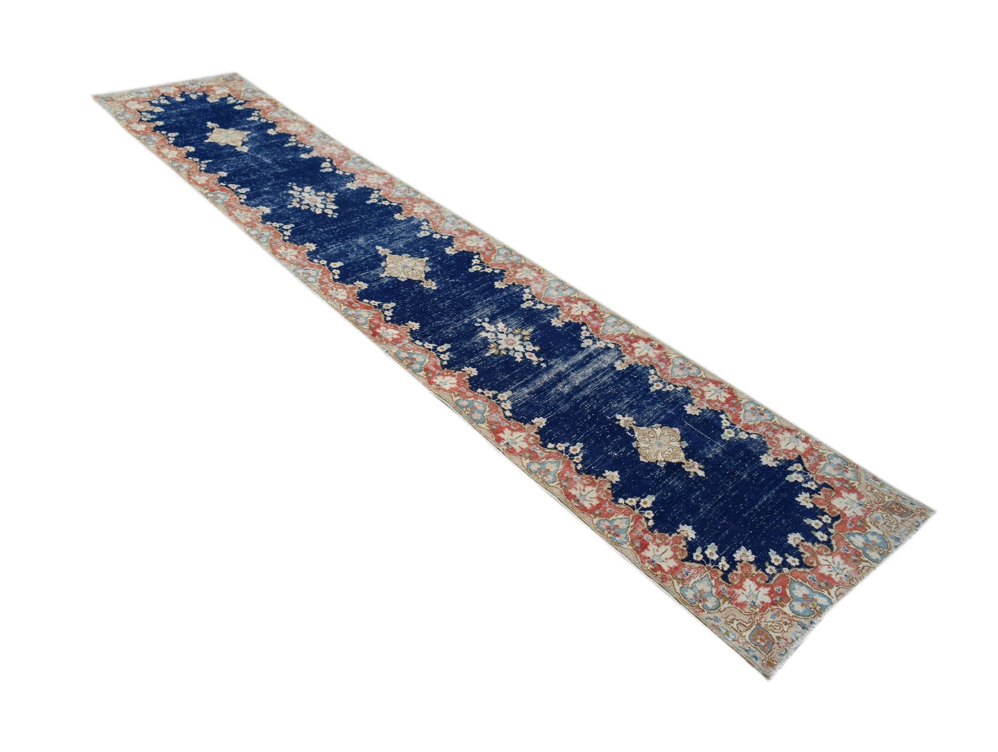 A vintage Persian Kerman runner featuring a deep blue field with intricate floral medallion motifs.