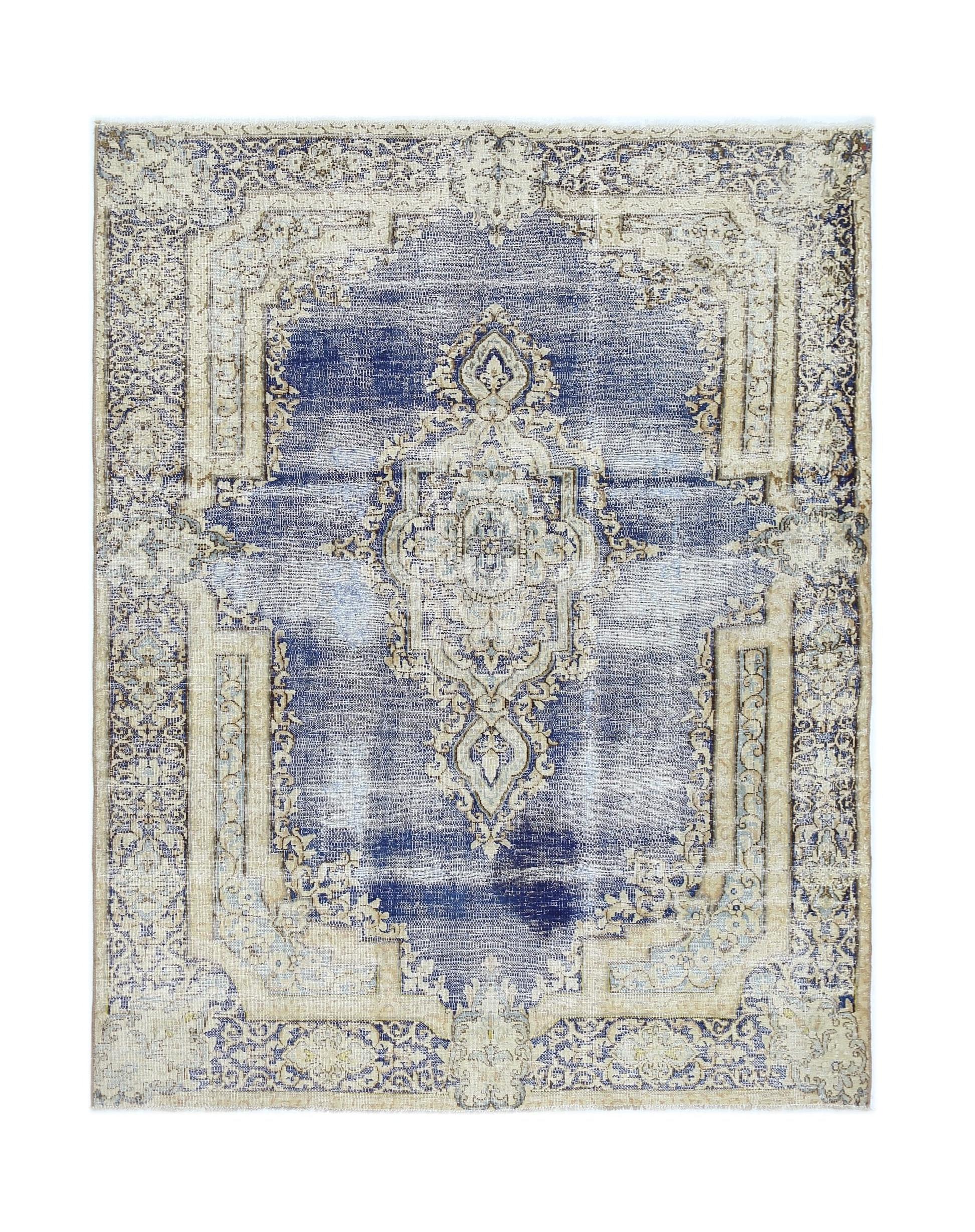 A vintage Persian Kerman rug featuring a central medallion and floral motifs in blue and beige.