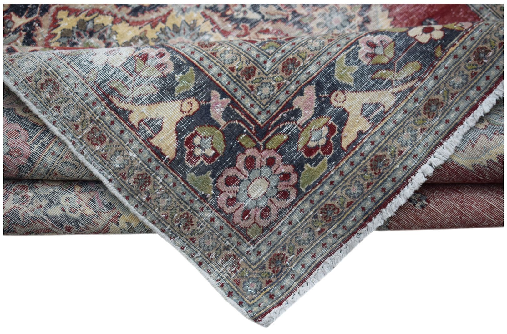 A vintage Persian Kerman rug featuring a dark blue border with intricate floral and animal motifs.