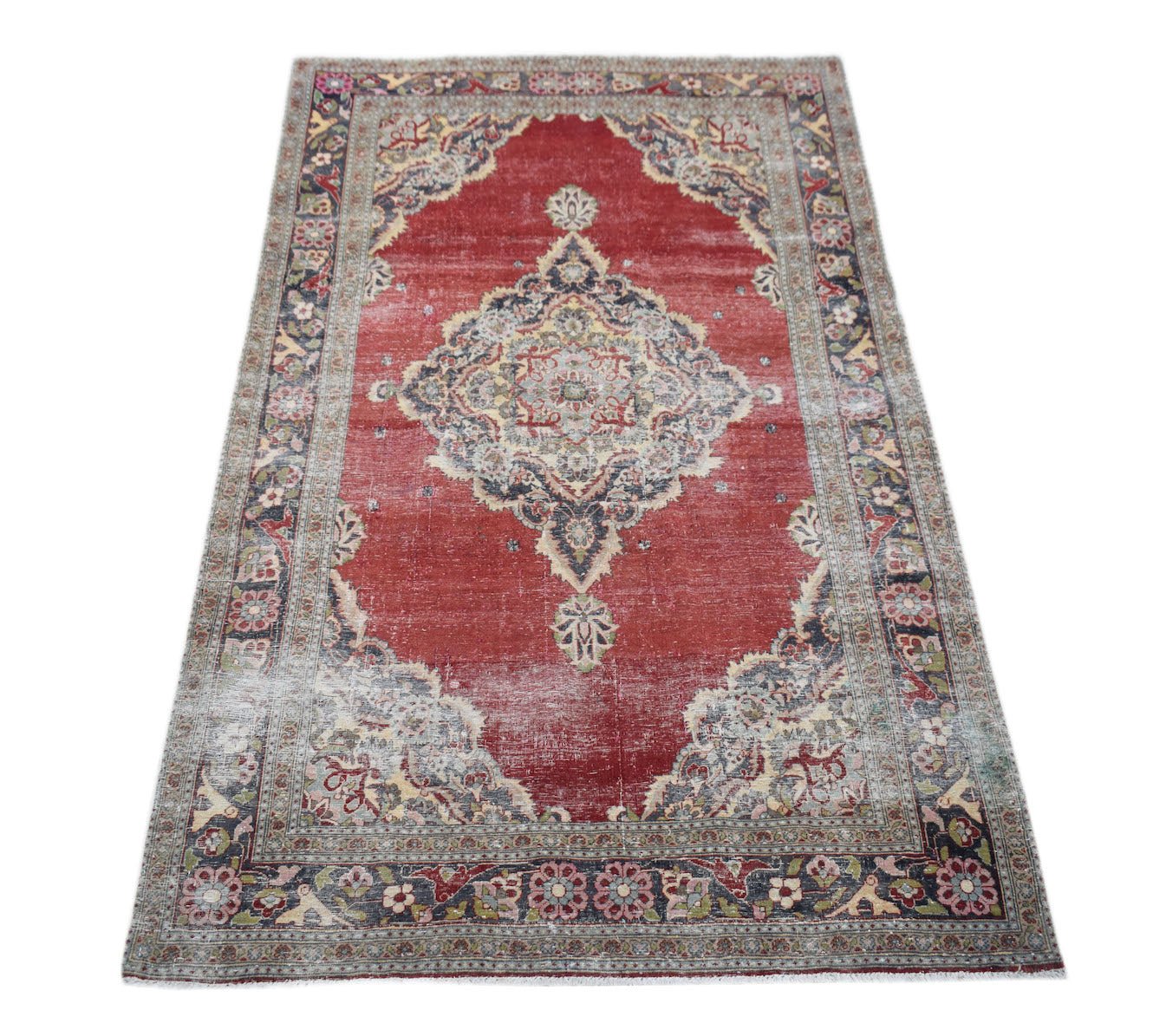 Vintage Persian Kerman rug featuring a central medallion and floral motifs on a red field.