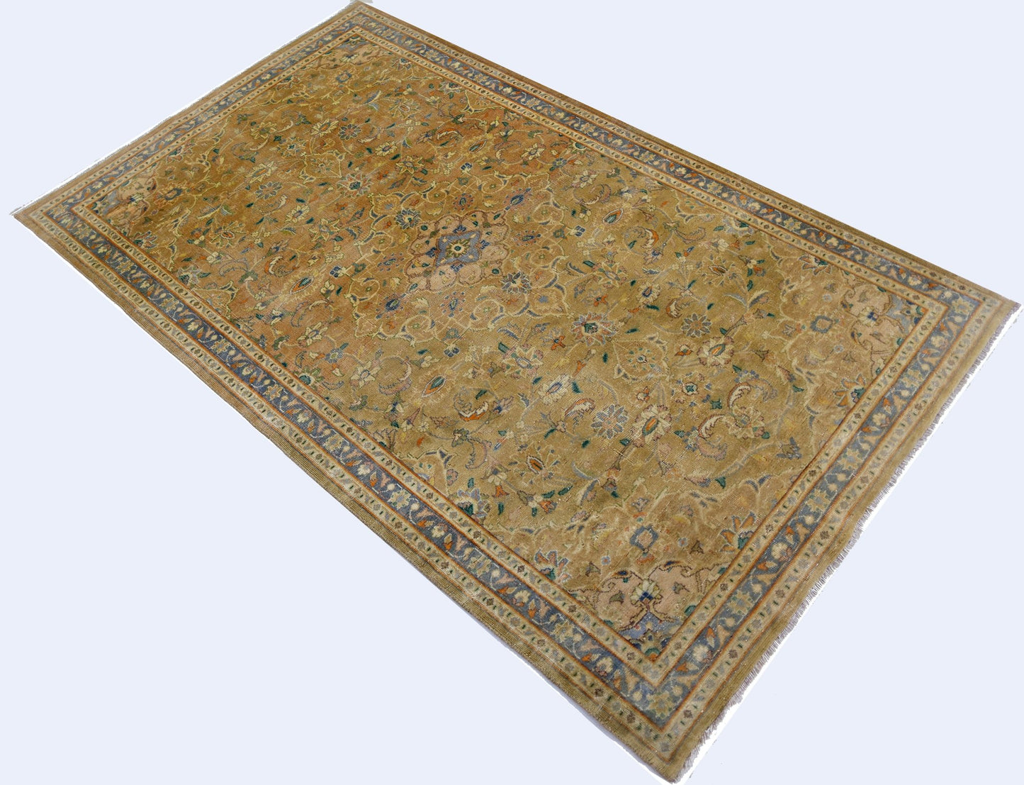A vintage Pakistani rug featuring an intricate floral medallion design in muted golden tones.