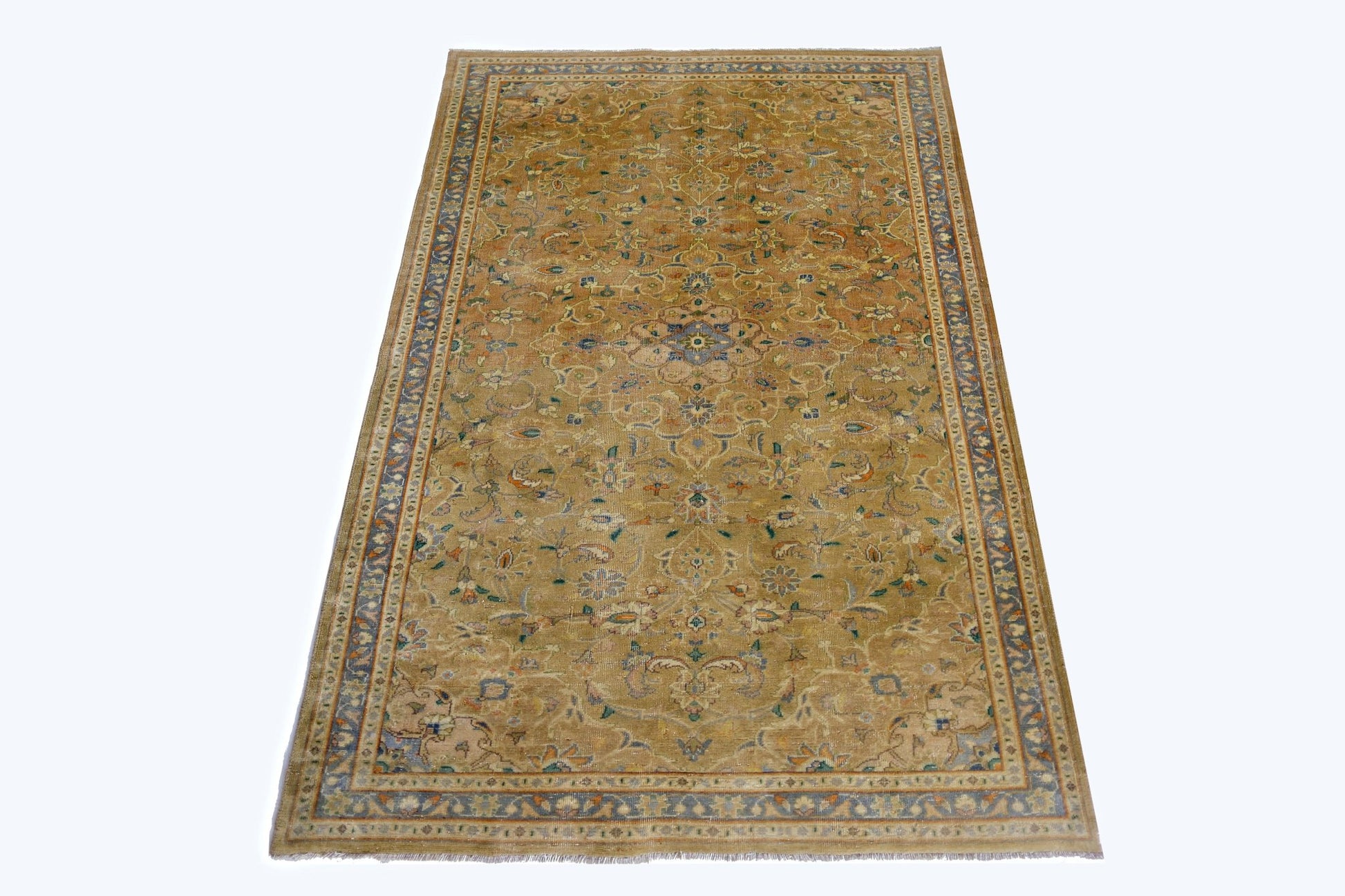 A vintage hand-knotted rug featuring a central floral medallion on a golden field with blue borders.