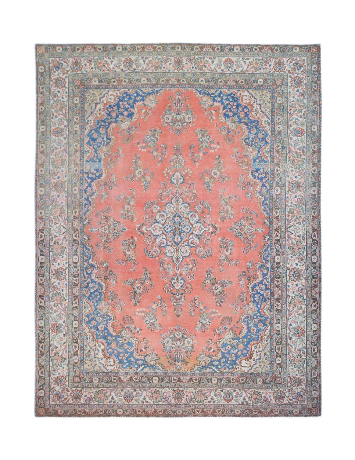 A vintage Persian Kerman rug featuring a central floral medallion on a coral field with blue borders.