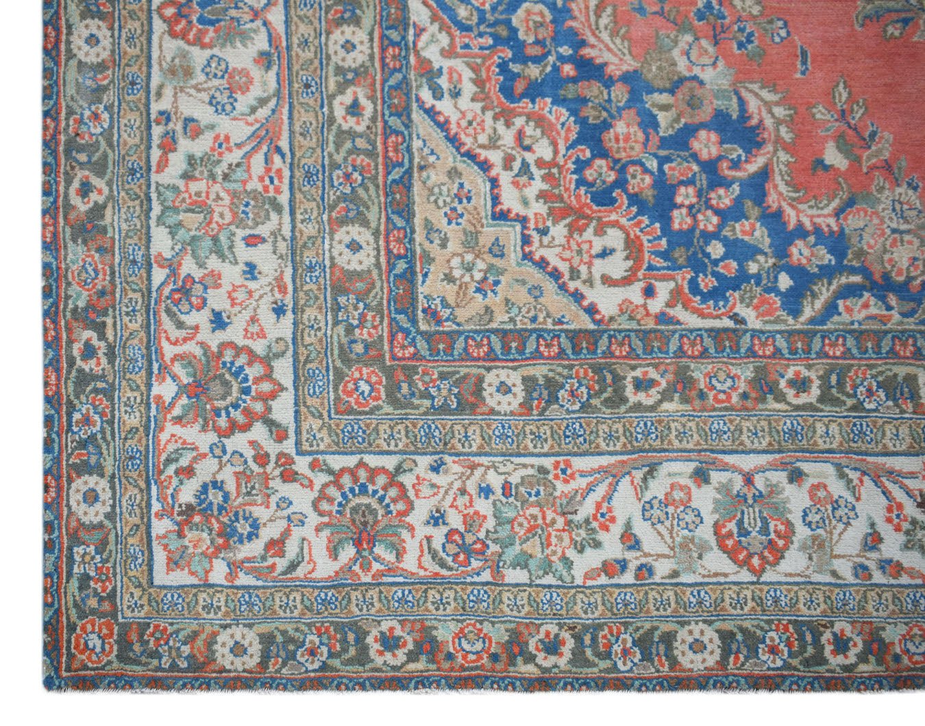 A vintage Persian Kerman rug featuring a floral medallion design in blue, red, and cream tones.