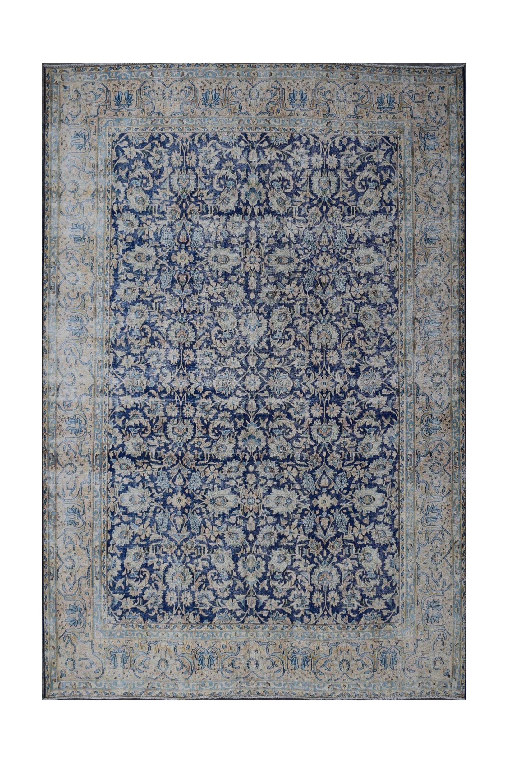 A vintage Persian Kerman rug featuring an intricate blue and cream floral pattern.