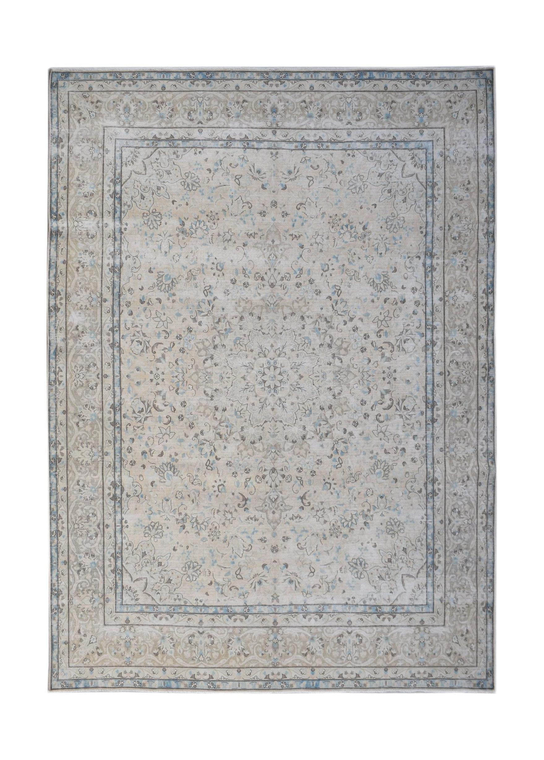 A vintage Persian Kerman rug featuring a central medallion and intricate floral patterns in blue.