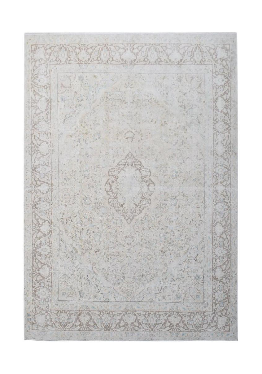 A vintage Persian Kerman rug featuring a central medallion and intricate floral border in beige.