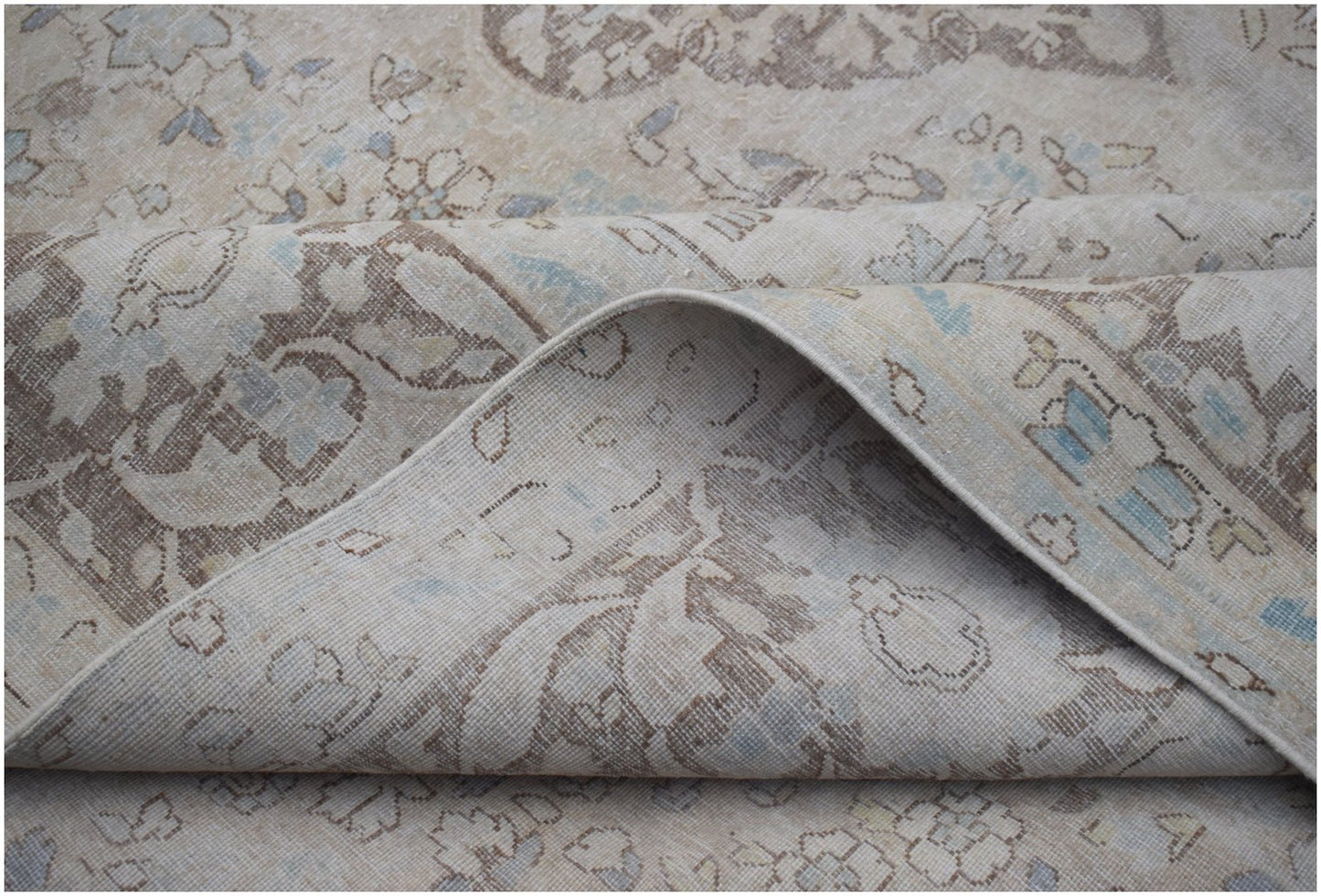 A vintage Persian Kerman rug featuring a soft beige palette with intricate floral patterns.