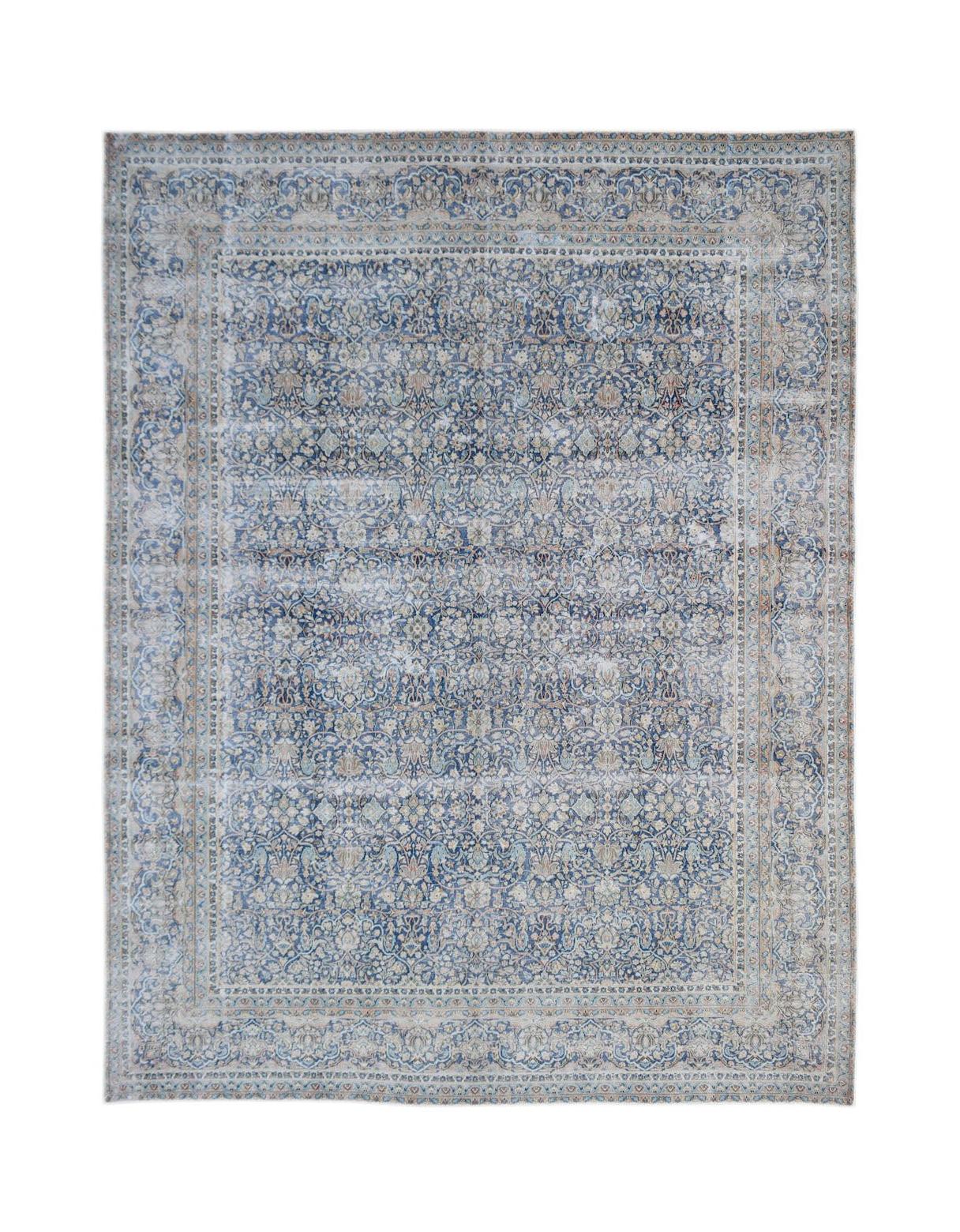 A vintage Persian Kerman rug featuring an intricate blue and cream floral medallion design.