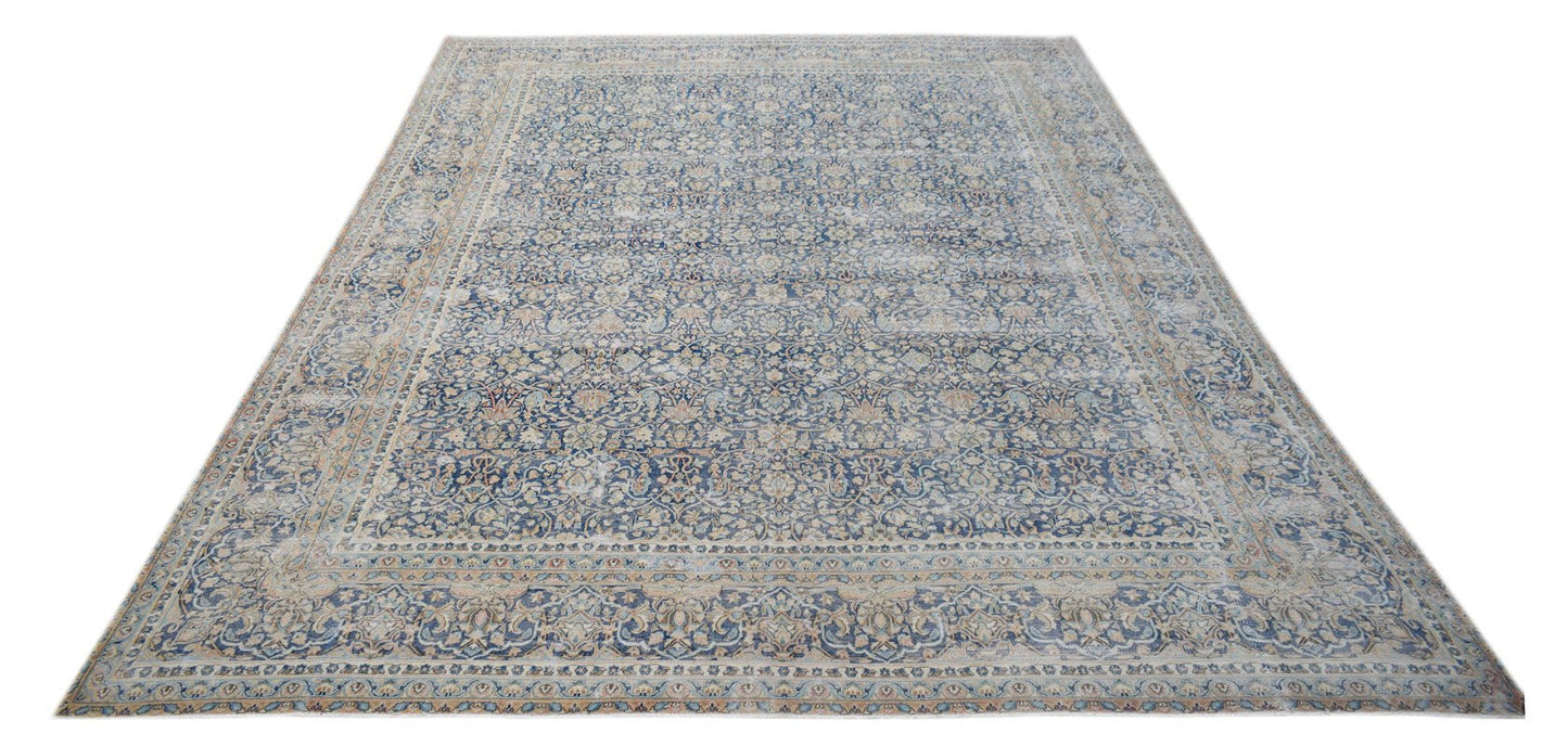 A vintage Persian Kerman rug featuring an intricate blue and cream floral medallion design.
