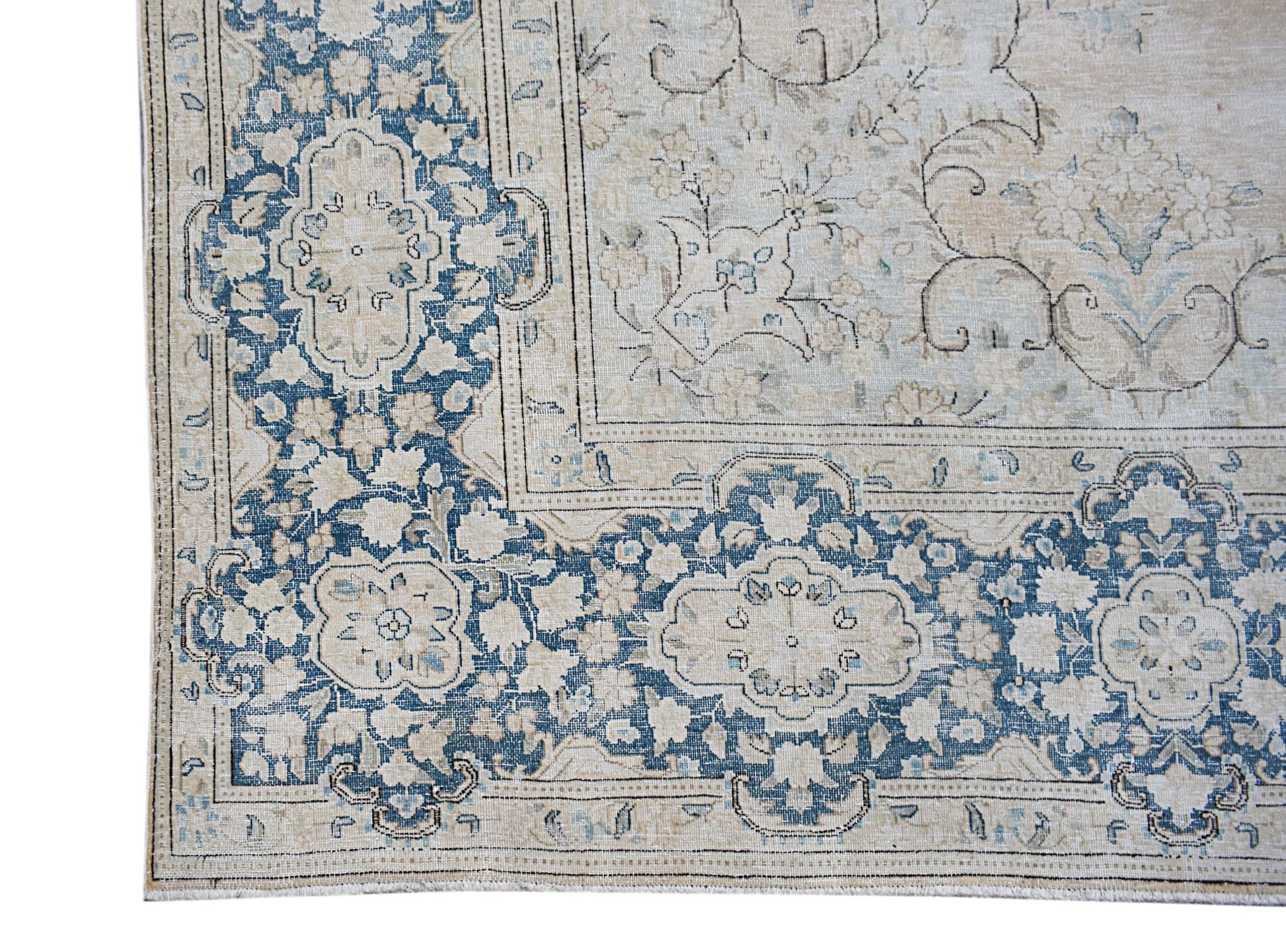 A vintage Persian Kerman rug featuring a blue and cream floral pattern with a central medallion.