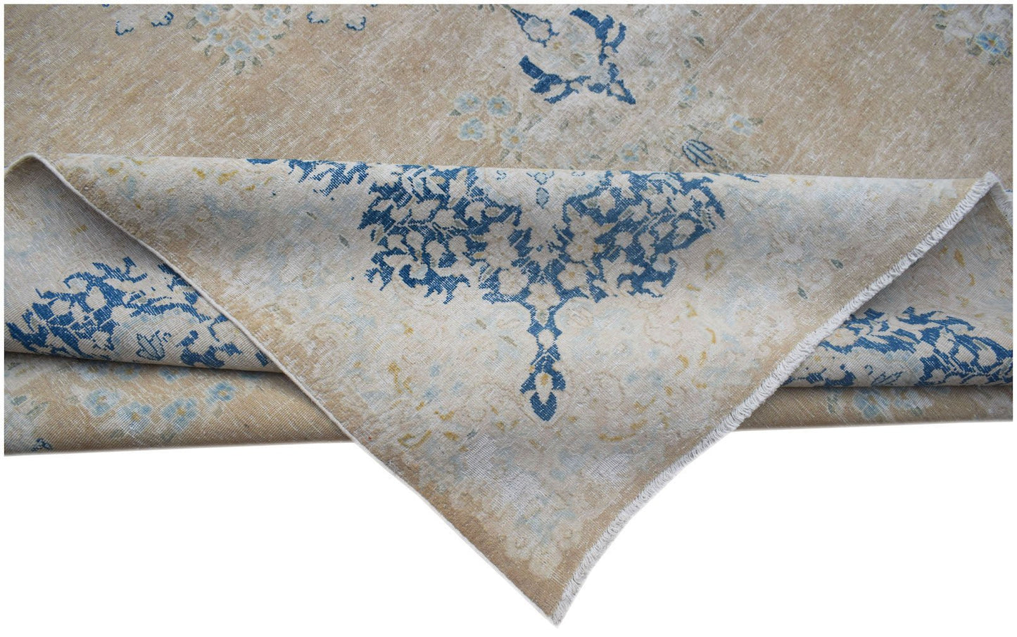 A vintage Persian Kerman rug featuring a blue floral medallion pattern on a tan background.