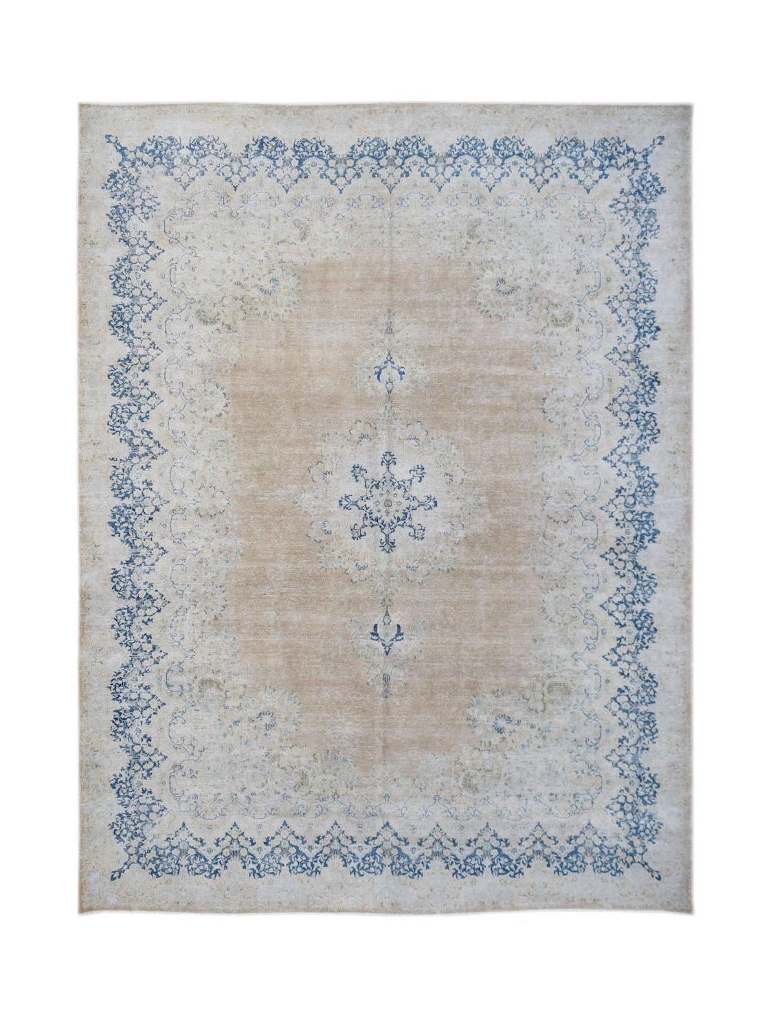 A vintage Persian Kerman rug featuring a blue floral medallion on a beige field with a blue border.