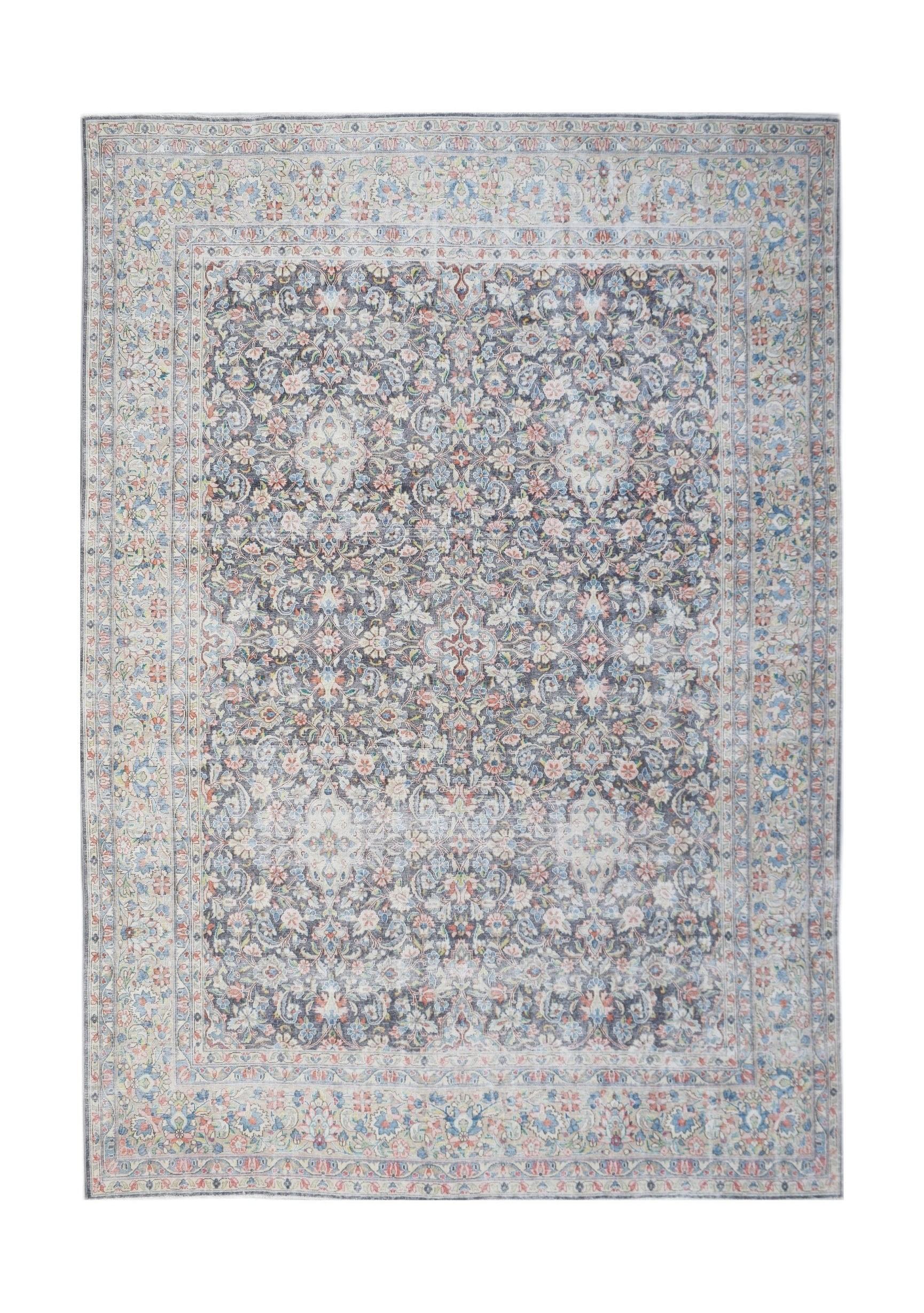 A vintage Persian Kerman rug featuring an intricate floral medallion pattern in muted tones.